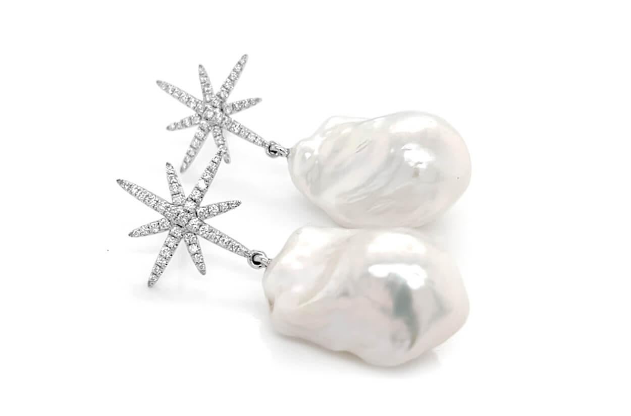 Graceful and unique, these 14kt white gold earrings showcase two natural baroque South Sea pearls, elegantly accented with star-shaped diamonds totaling 0.55 carats. A refined blend of organic beauty and celestial sparkle, they make a timeless gift