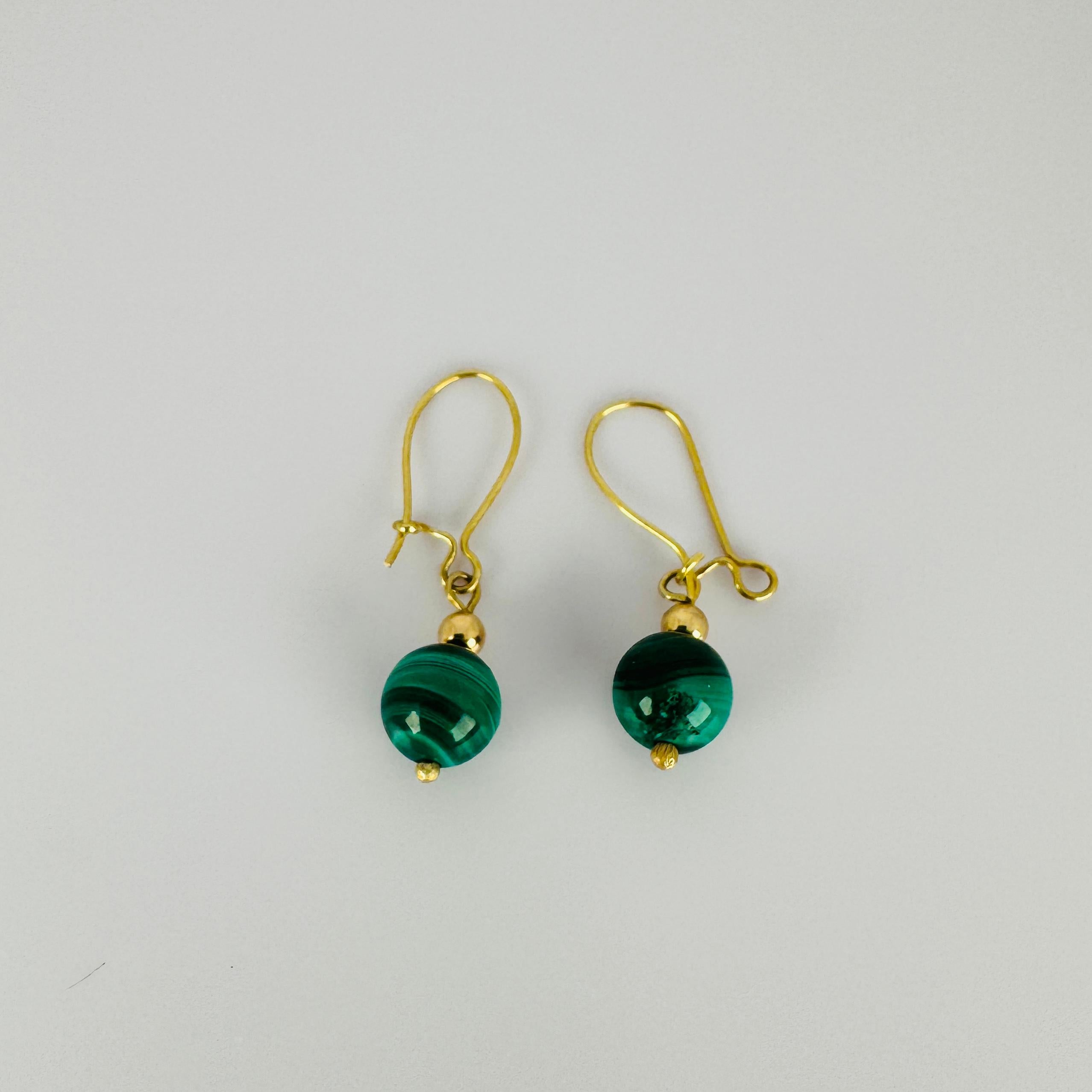 These vintage earrings carry a refined charm into every moment. The deep green malachite stones and warm gold tones come together in a subtle yet striking statement. Each pair tells its own story – a piece of the past, a spark of the present.

   