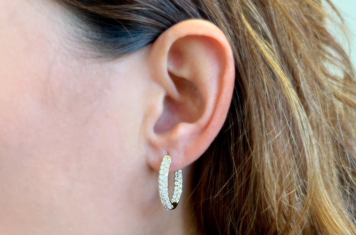 These earrings hoops are a radiant embodiment of luxury and sophistication. Crafted from lustrous 18kt yellow gold, they feature three rows of exquisite diamonds that encircle the hoops with brilliance and elegance. With each turn of the head, these