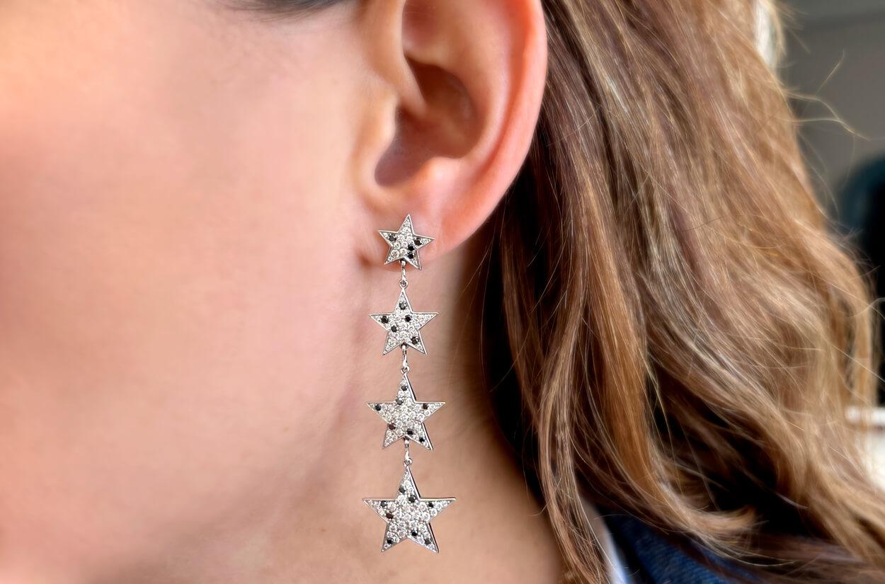 Embrace celestial contrast with these extraordinary 18kt White Gold Inline Star Earrings adorned with both black and white diamonds. Each earring captures the essence of the night sky, where the interplay of light and darkness is a breathtaking