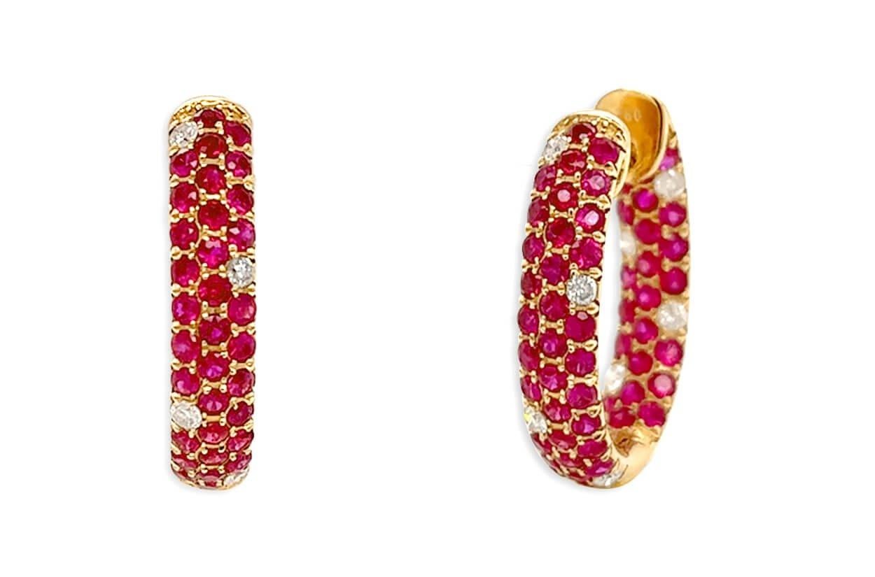Radiating warmth and opulence these 18kt yellow hoop earrings are adorned with fiery allure of rubies and timeless brilliance for diamonds. The hoops gracefully embrace your ears, while the rich red hues of rubies and the scintillating sparkle of