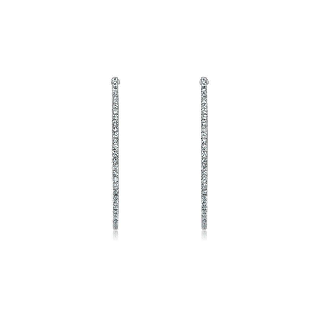 Ces élégantes boucles d'oreilles rondes en or blanc 18kt, ornées de 1,20 carats de 136 diamants éblouissants, offrent une touche raffinée de luxe et de sophistication intemporelle. Leur design délicat capte magnifiquement la lumière, ajoutant un