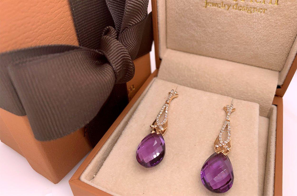 Elevate your style with these enchanting dangle earrings crafted in 14kt rose gold. They showcase the deep and mysterious beauty of two amethyst briolettes, which swing gently, catching the eye with their captivating hues. The amethysts are