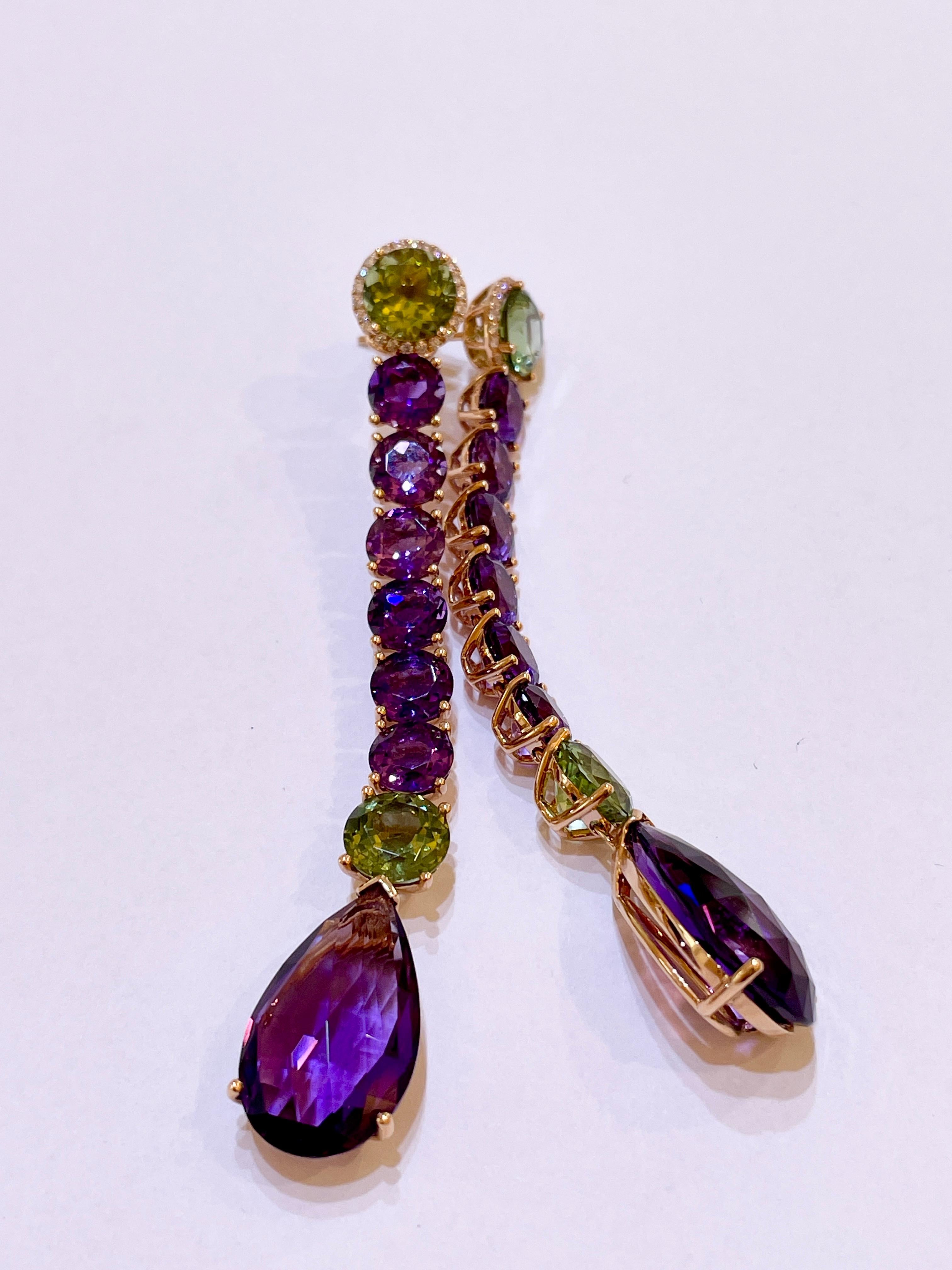 These beautiful long earrings with 47.67ct Amethyst, Peridot, and Diamonds are set in 18kt rose gold. They are a unique piece from our own workshop. 

The length of the earrings is 8.8cm. The earrings can also be shortened upon request.