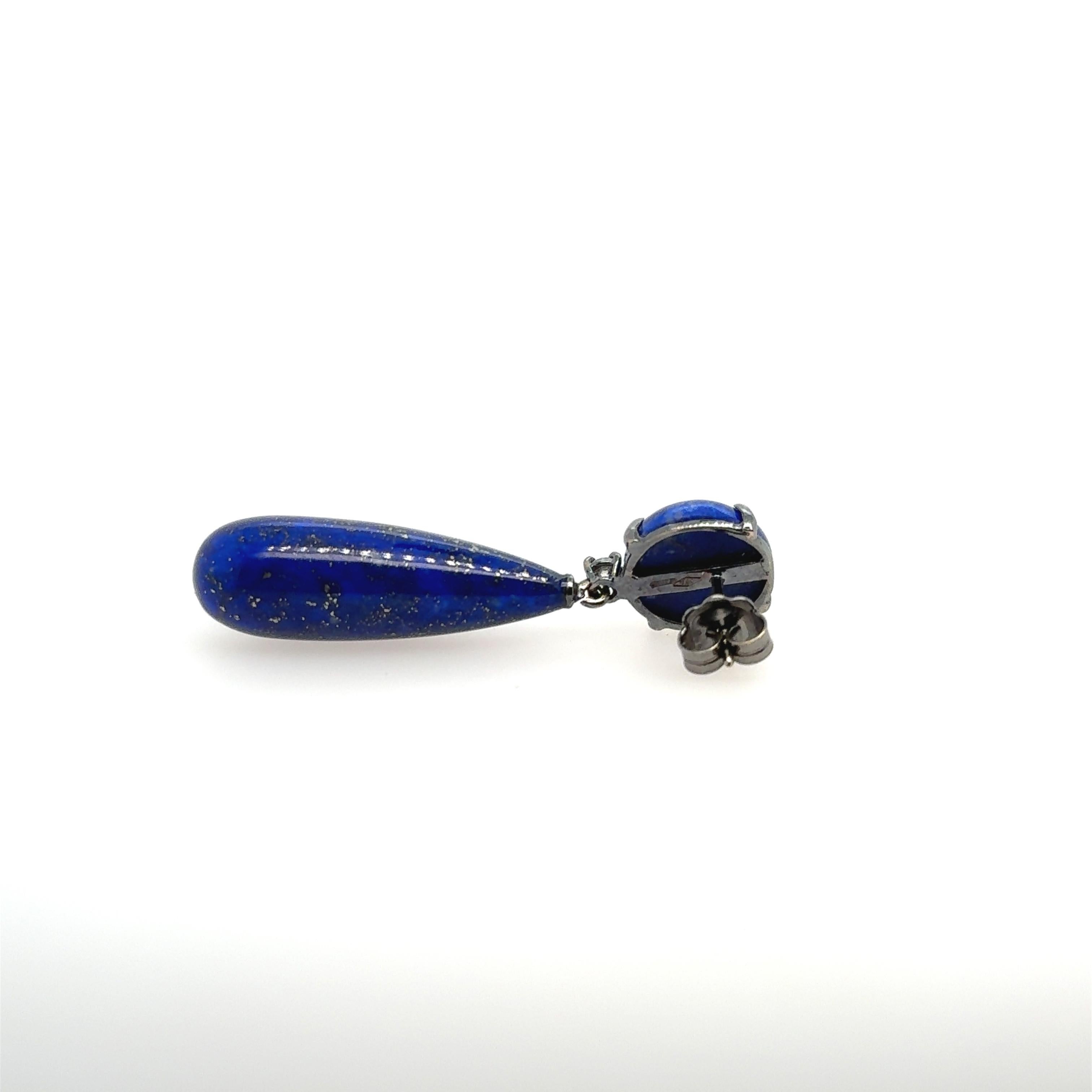  Lapis Lazuli Diamonds earrings in 18-carat black gold.
This pair of earrings consists of a cabochon-shaped lapis lazuli mounted on an articulated 18-carat black gold hanger. A brilliant-cut diamond separates it from the second, candelabra-shaped