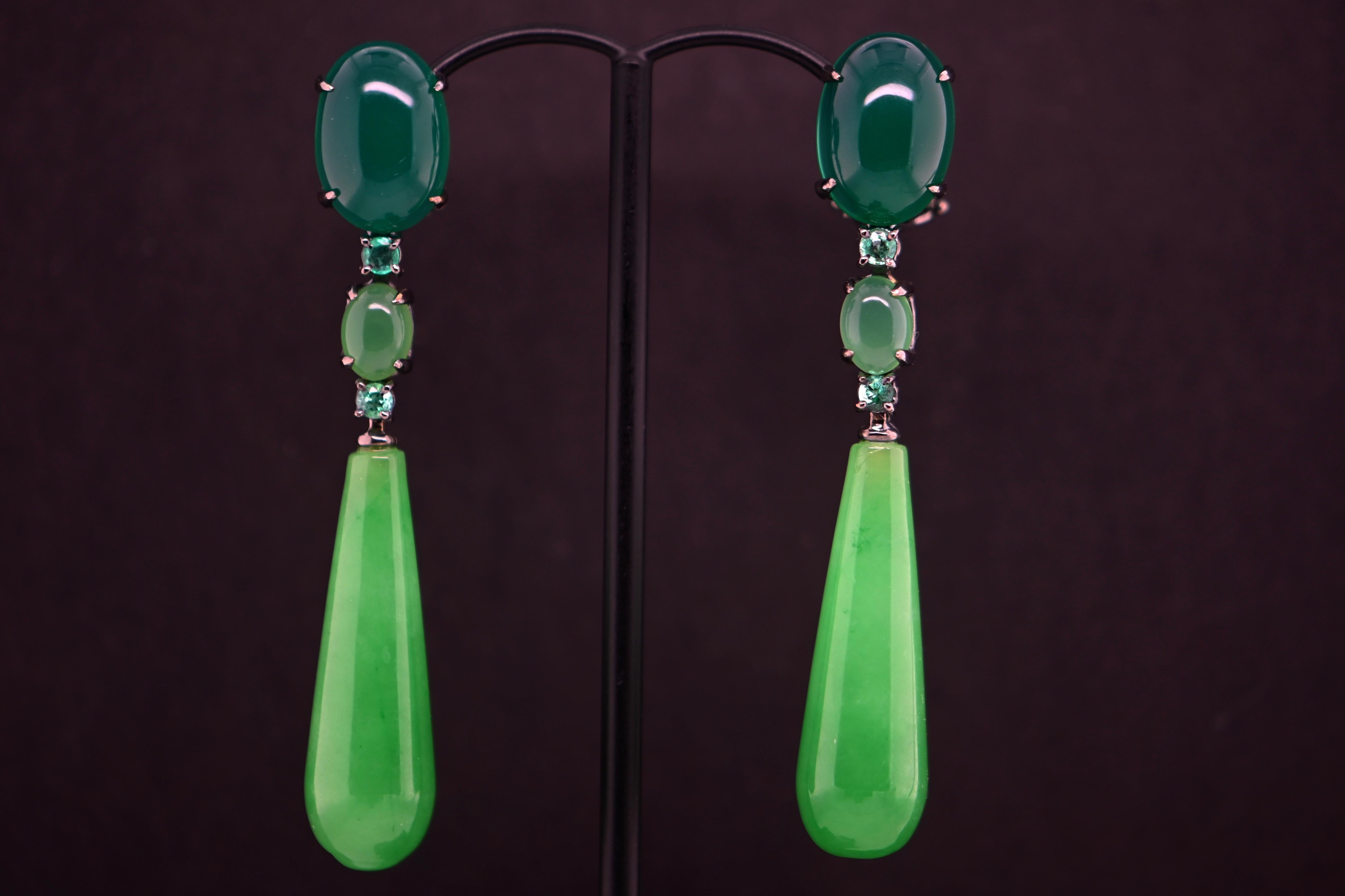 Discover the refined elegance of these green agate and jade earrings, adorned with two 32-carat emeralds. These exquisite earrings beautifully combine the rich hues of green agate and jade, highlighted by the brilliance of the emeralds, all set in