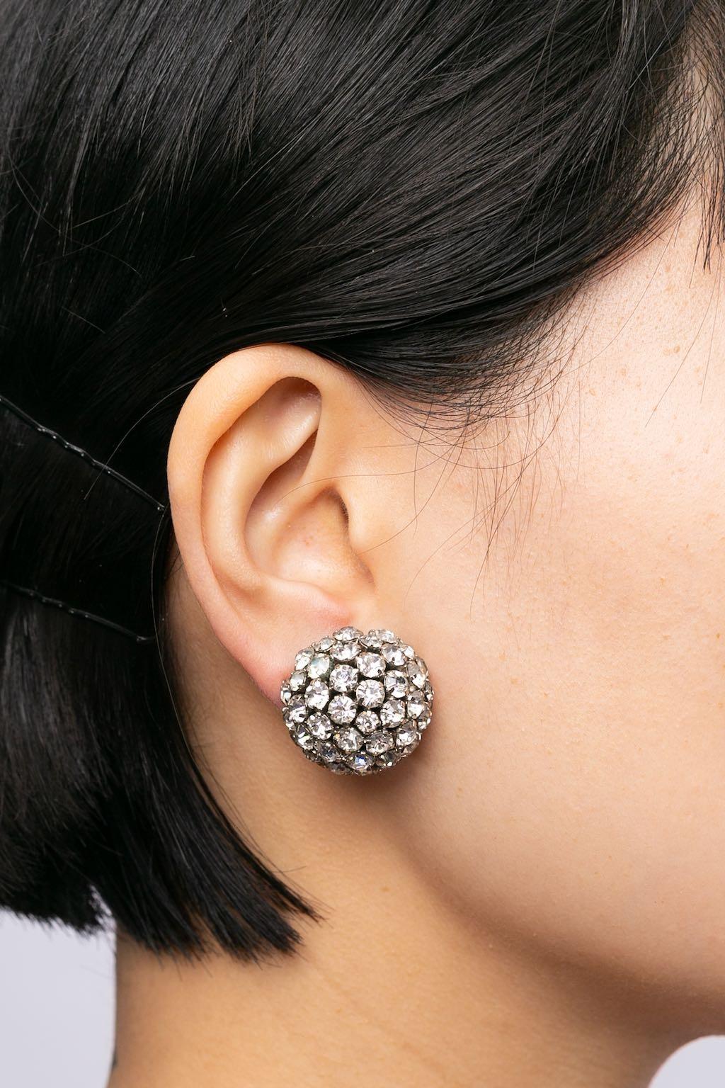 Ohrringe aus silbernem Metall mit Strasssteinen besetzt.

Zusätzliche Informationen:
Zustand: Sehr guter Zustand
Abmessungen: Durchmesser: 2,5 cm (0,98