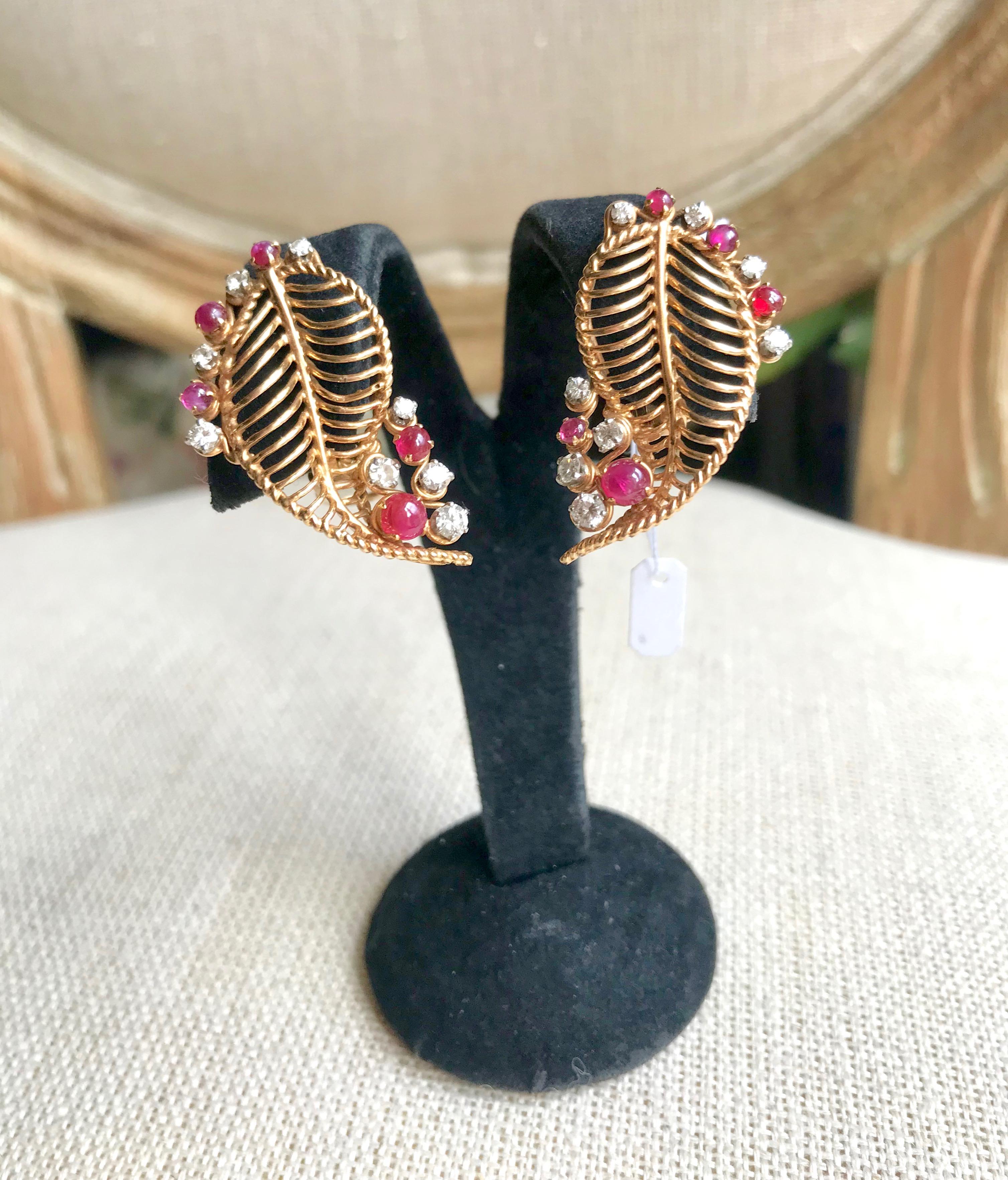 Vintage Earrings Circa 1950 in 18 Carat yellow Gold, Cabochon Rubies and Diamonds. Earrings for pierced Ears representing Leaves each holding 8 Diamonds and 5 Cabochon Rubies. Period around 1950 
Gross weight: 13.1 g 
Length 3.5 cm