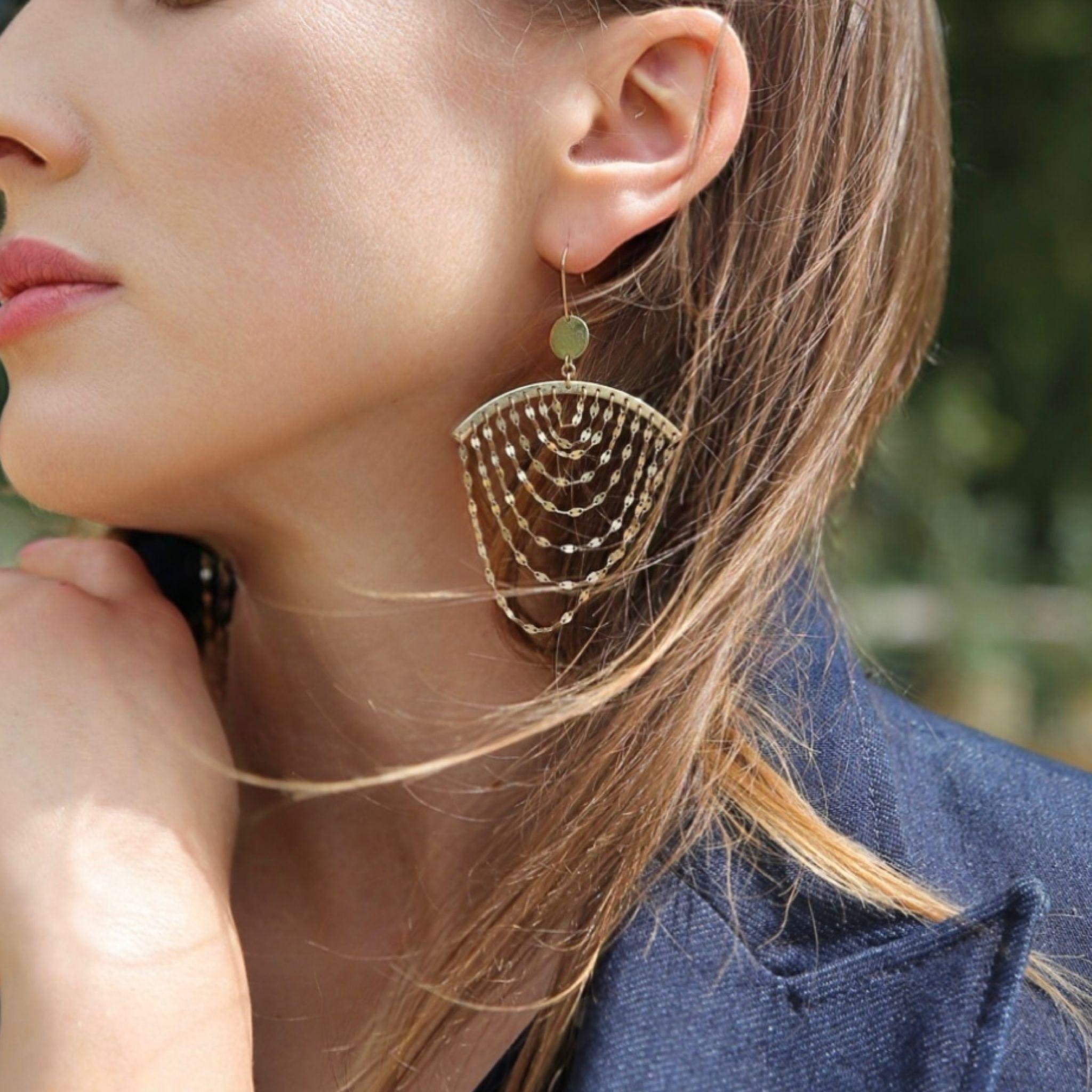 Crafted in polished 14-karat yellow gold, these Lana cascade earrings are a refined take on the classic chandelier silhouette. The design features a series of delicate flat-link chain drapes, suspended from a subtly curved bar, creating elegant