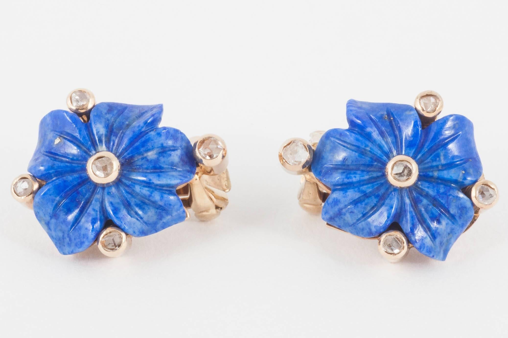 A pair of 18 karat yellow gold earrings set with a lapis lazuli carved flower head with five, rose cut diamond collets. Clip and post ear fittings. The original clip fittings are stamped with the 585 mark for 14 karat gold together with the initials