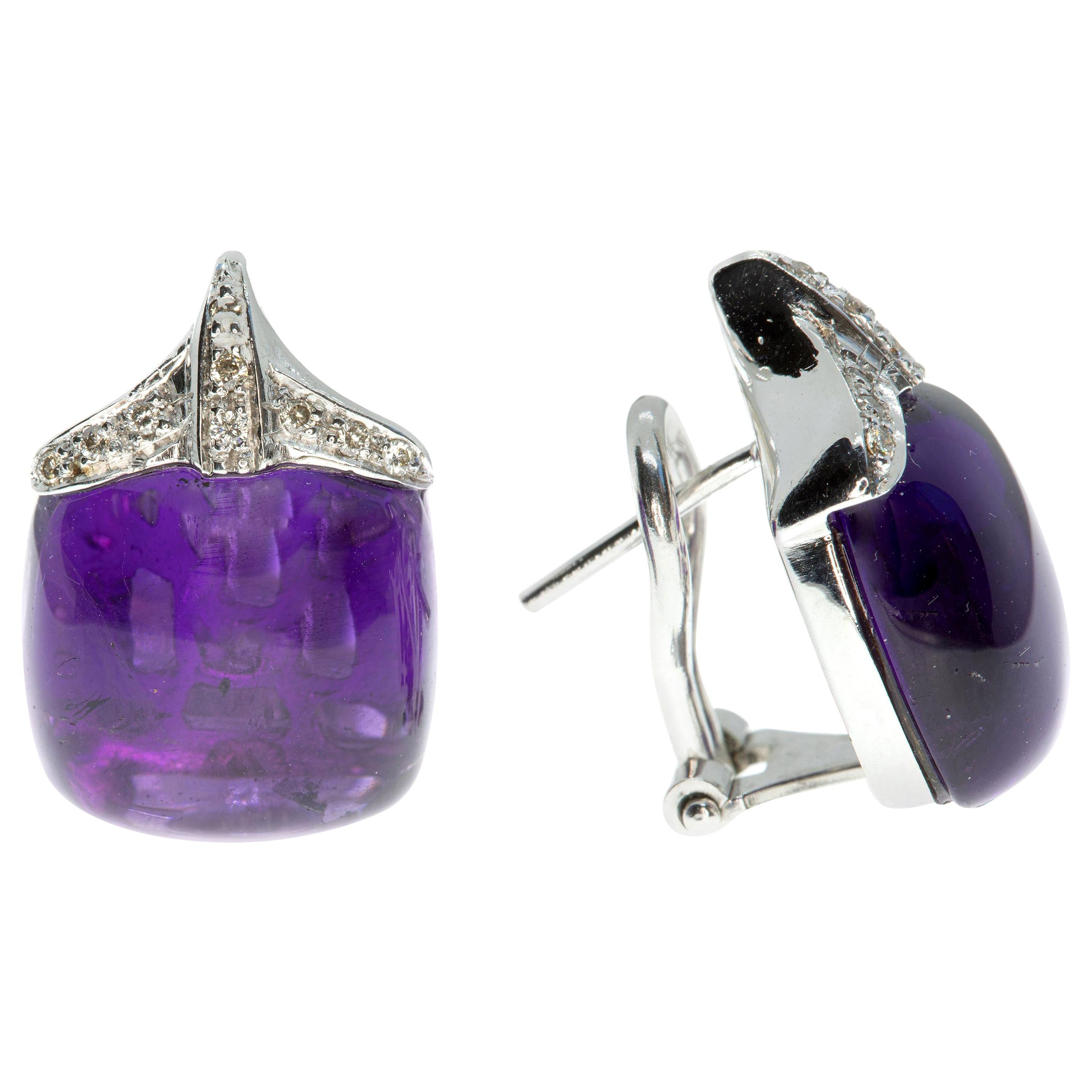 These earrings, masterfully created by hand from 18 karat white gold, each feature a large amethyst stone capped with pavé-set white diamonds.

This is a beautiful pair of earrings; exceptional to view and easy to wear. They have post-backs with