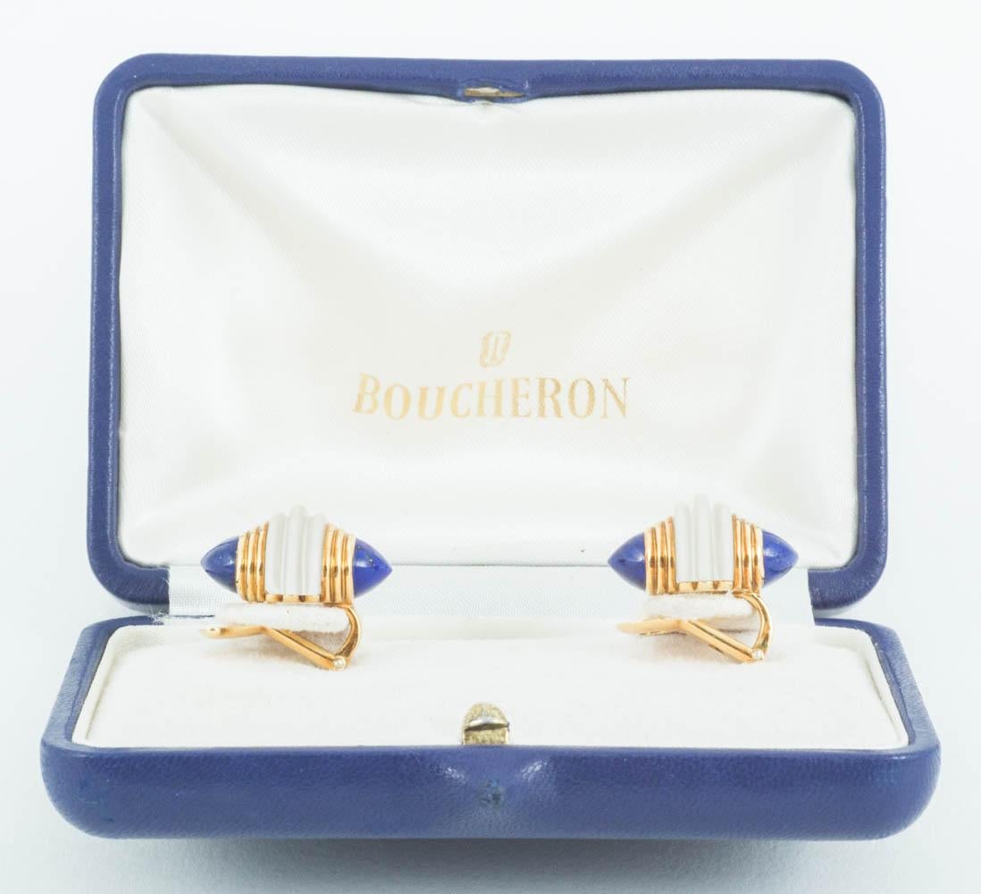 A finely made pair of vintage clip earrings by Boucheron in 18 karat yellow gold. The centre of each earring has a ring of frosted crystal with patterned gold and lapis lazuli either side. Signed Boucheron with French marks and numbered 1432. Fitted