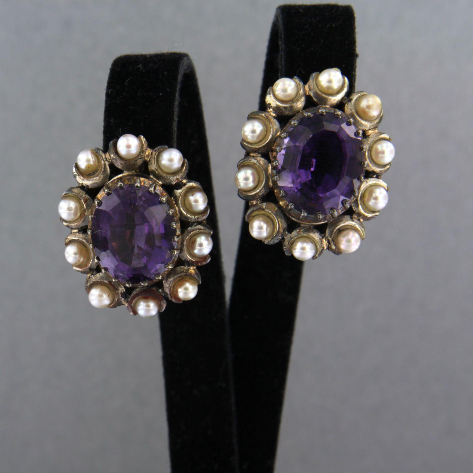 18k gold with silver ear clips with a central amethyst and entourage of pearls

detailed description:

the top of the ear clip is 2.3 cm high and 1.9 cm wide

weight 13.6 grams

set with

- 2 x 1.2 cm x 1.0 cm oval facet cut amethyst

color