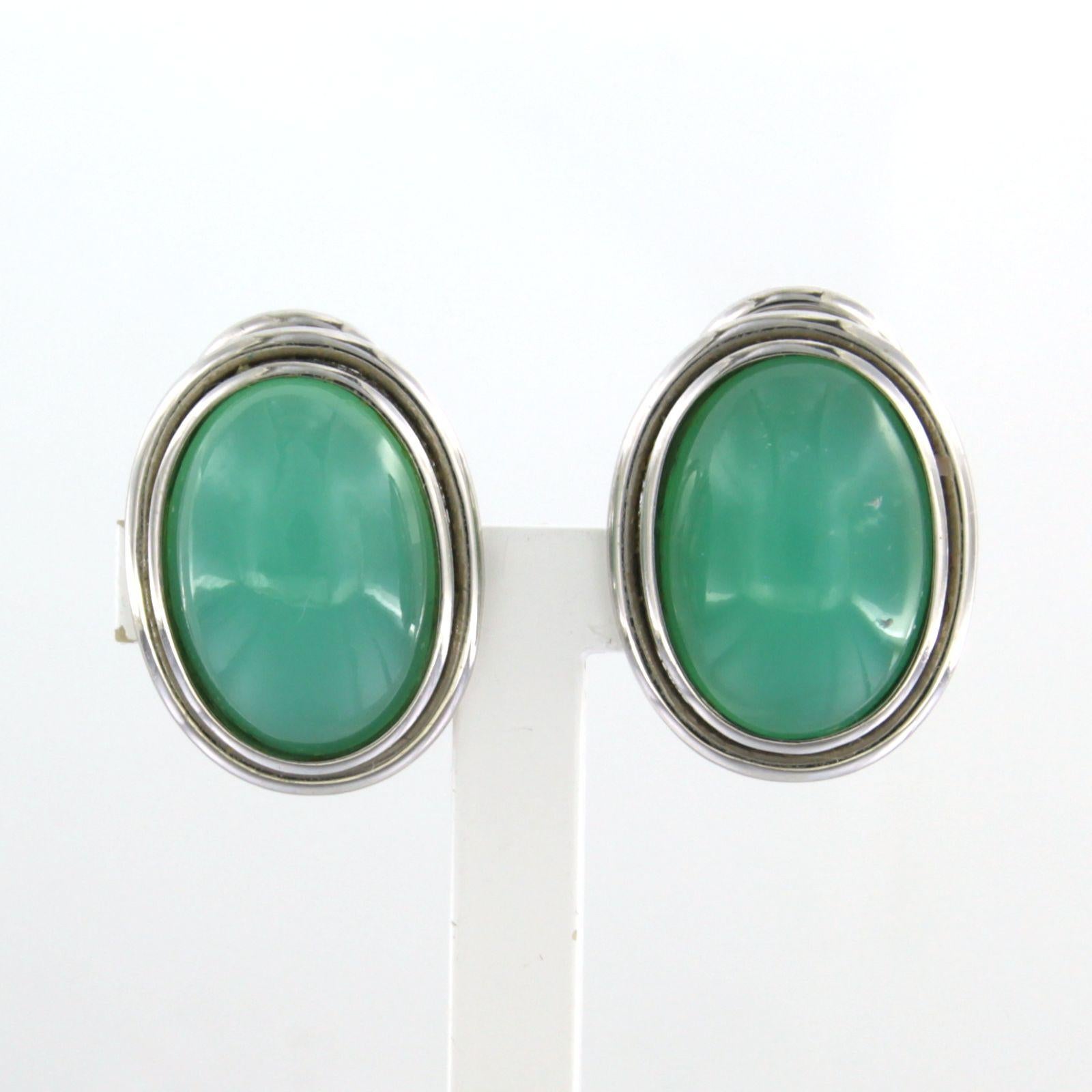 18k white gold clip-on earrings set with chrysophrase

Detailed description:

The ear clips are 1.7 cm high and 1.3 cm wide

Total weight 9.4 grams

set with

- 2 x 1.4 cm x 1.0 cm oval cabochon cut chrysoprase

color: green
purity: n/a
Gemstones