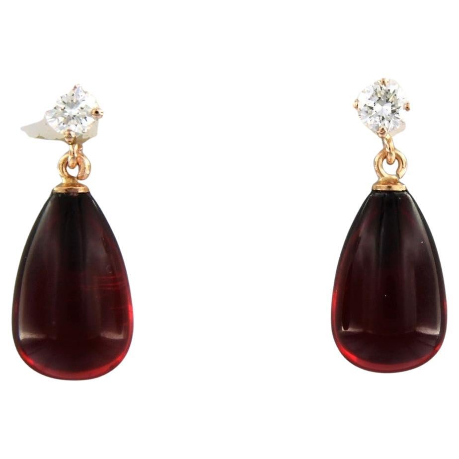 18 kt rose gold earrings set with red garnet and brilliant cut diamonds. 0.36 ct - F/G - VS/SI

detailed description:

the size of the earring is 2.0 cm long by 8.3 mm wide

weight 2.4 grams

occupied with

- 2 x 8.3mm x 1.3cm drop shape cut red