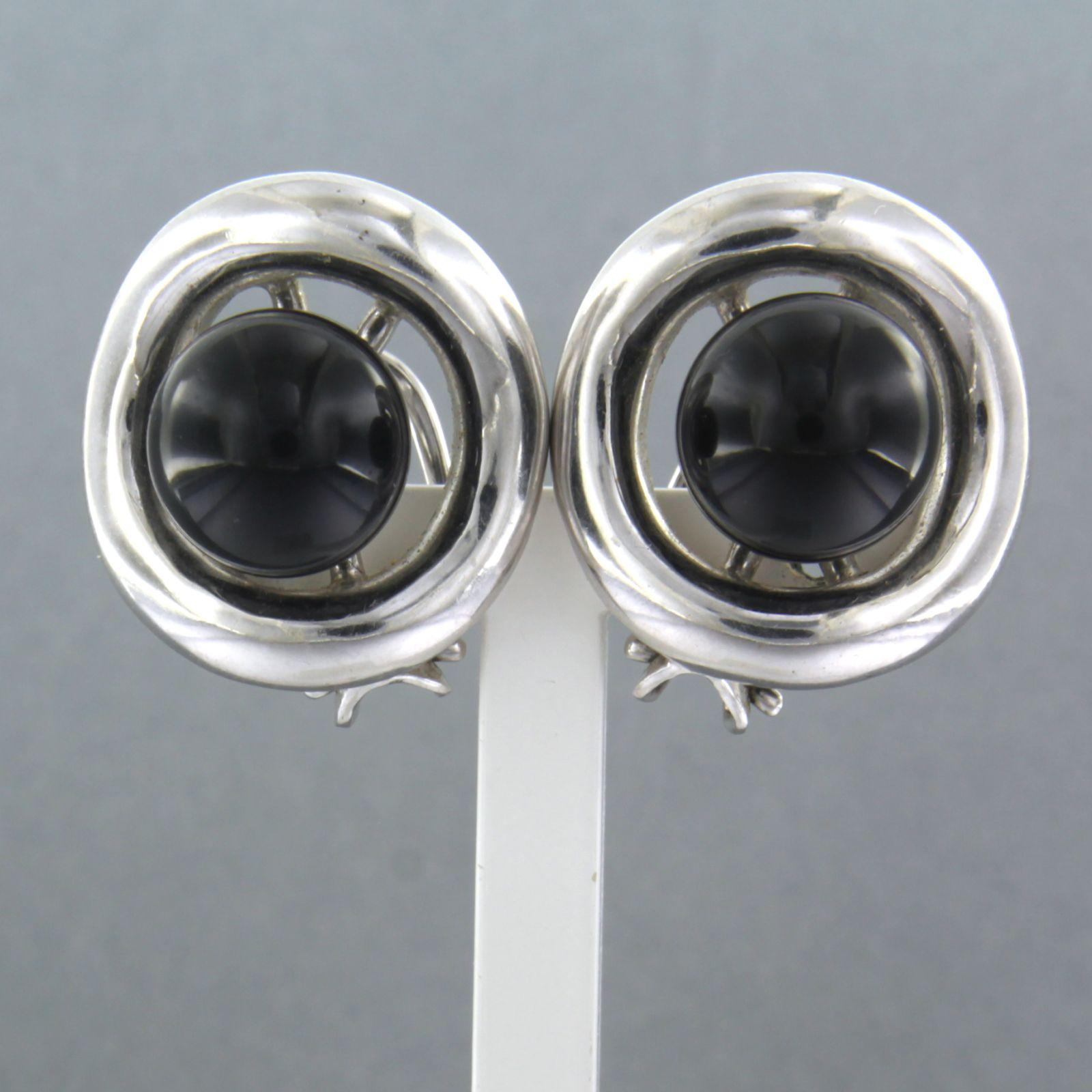 18k white gold ear clips set with onyx

detailed description:

the top of the ear clip is 2.0 cm high and 1.8 cm wide

Weight 14.0 grams

Occupied with

- 2 x 1.0 cm bead shape cut onyx

colour black
purity n/a
Gemstones have often been treated to