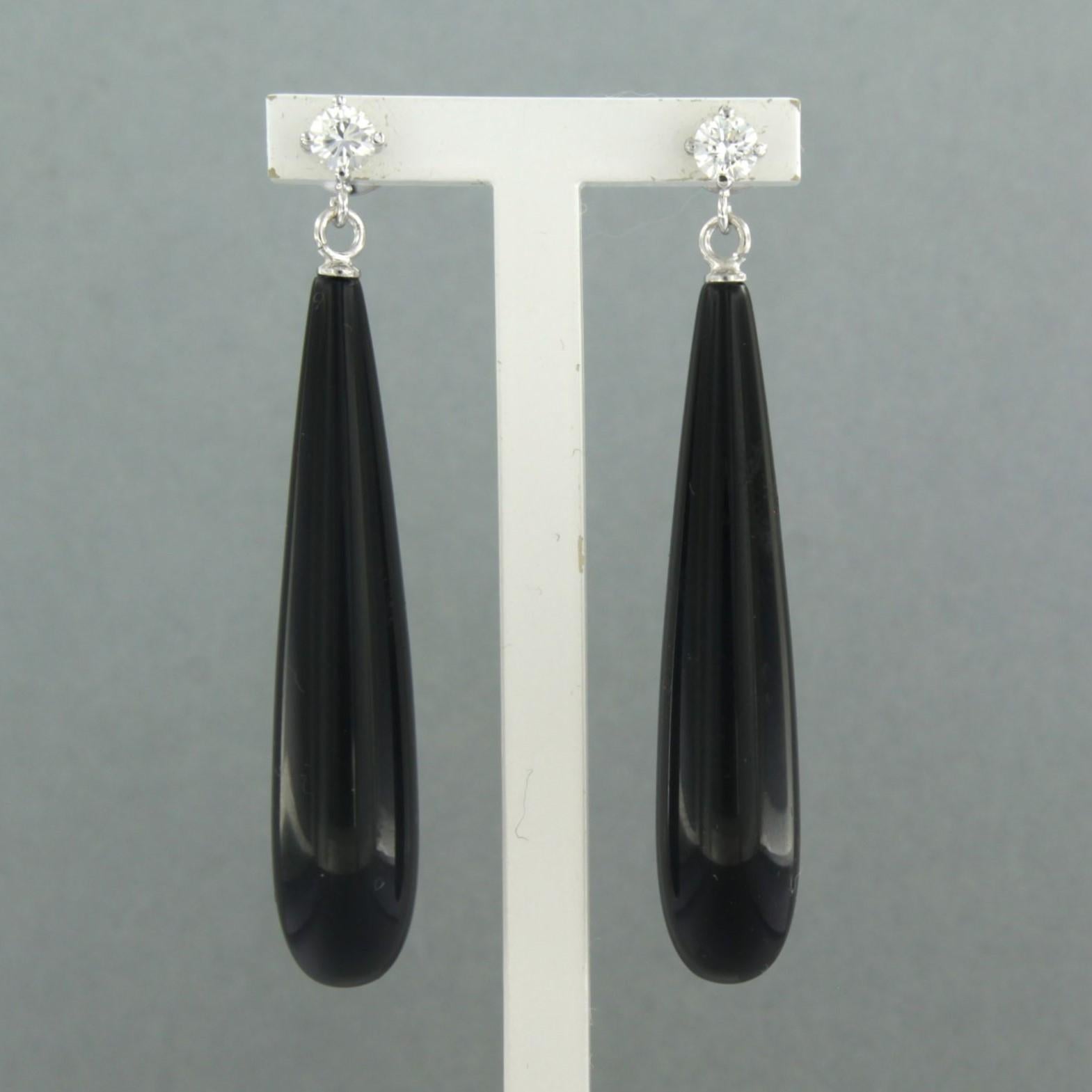 18k white gold earrings with onyx and brilliant cut diamonds. 0.38ct - F/G – VS/SI

Detailed description:

the size of the earrings is 5.0 cm long by 8.3 mm wide

Total weight 8.7 grams

set with

- 2 x 4.0 cm x 8.3 mm drop shape cut onyx

colour