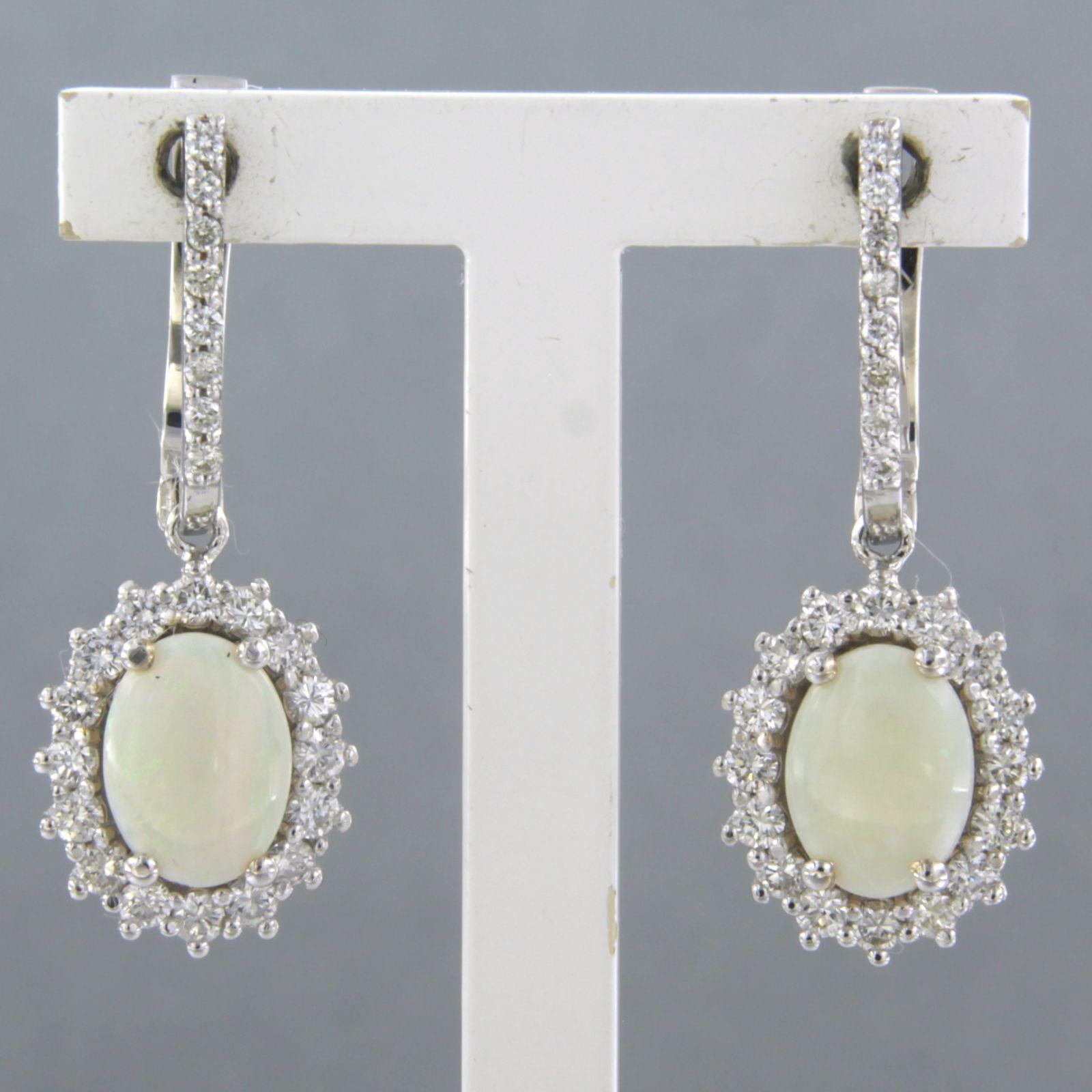 18k white gold earrings set with opal and brilliant and diamonds 0.66ct - F/G - VS/SI

detailed description:

the earrings are 2.8 cm high and 1.0 cm wide

weight 5.8 grams

set with

- 2 x 8 mm x 6 mm oval cabochon cut opal

color white, green,