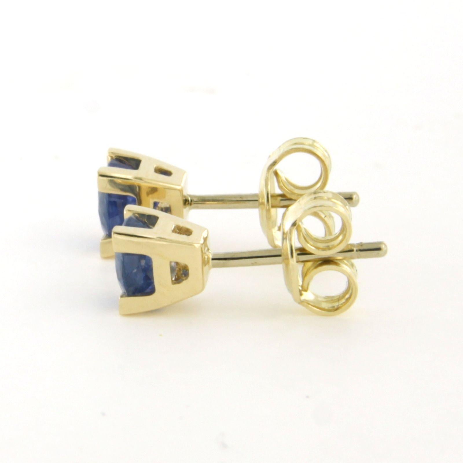 14k yellow gold solitaire stud earrings set with sapphires, totaling approximately 1.26 ct – 1.8 grams

Detailed description:

The stud earrings have a square setting, 5.1 mm wide.

Total weight: 1.8 grams

Set with:

- 2 x 4.8 mm round facet-cut