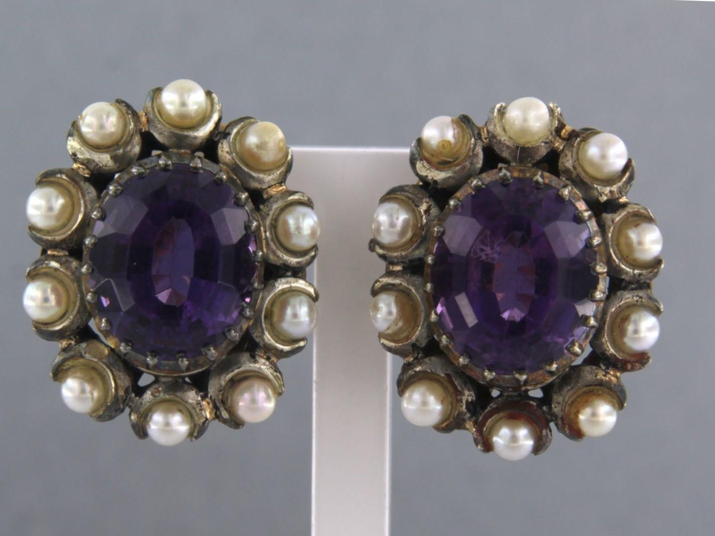 18k gold with silver ear clips with a central amethyst and entourage of pearls

detailed description:

the top of the ear clip is 2.3 cm high and 1.9 cm wide

weight 13.6 grams

set with

- 2 x 1.2 cm x 1.0 cm oval facet cut amethyst

color: