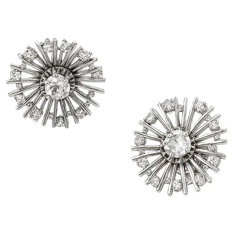 A rare and exquisite pair of French Art Deco “Dandelion” earrings, crafted circa 1940 in finely polished white gold (approx. 11 grams).

Each earring features a central old-cut diamond with a combined approximate weight of 0.35 ct, surrounded by an