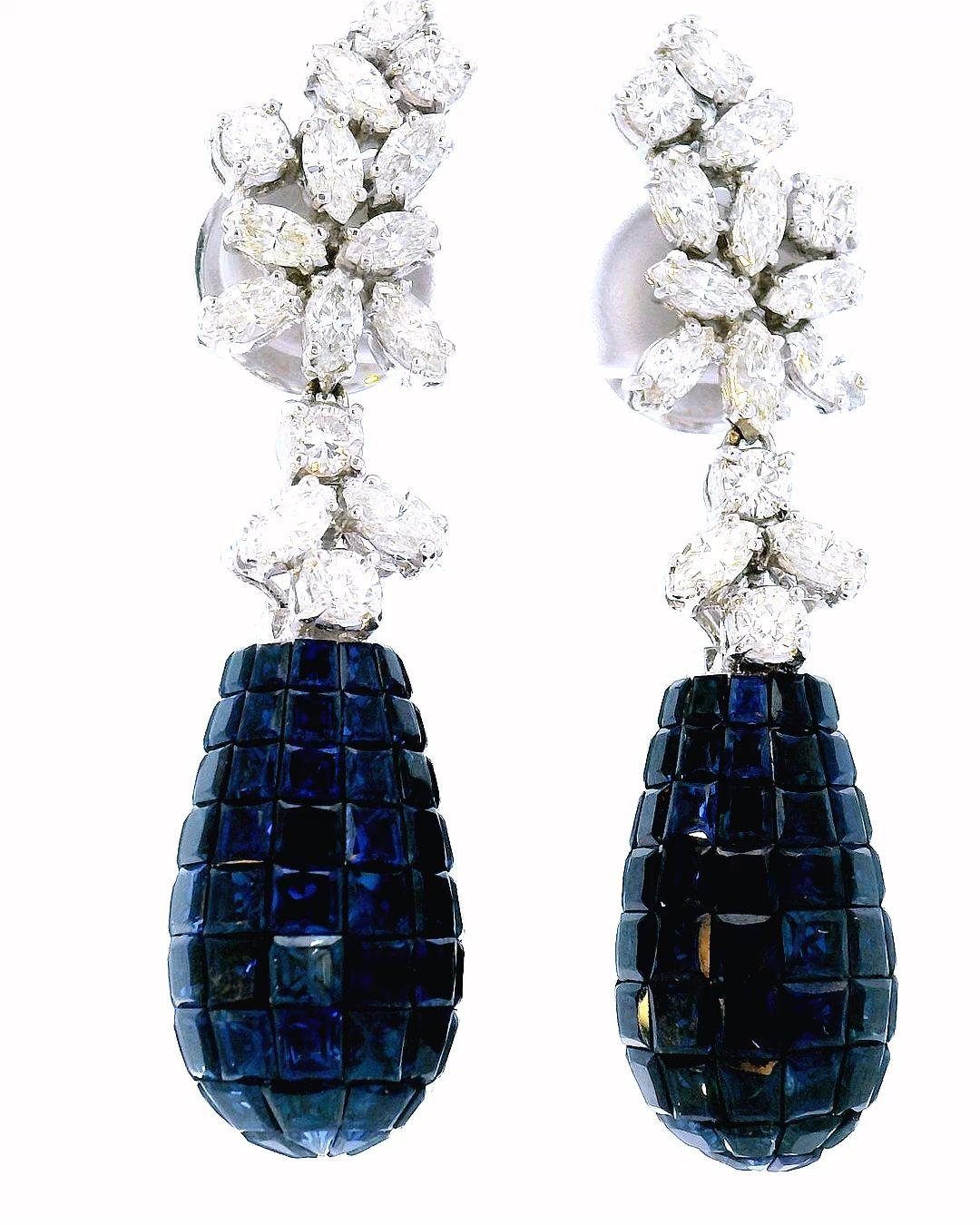 Elevate your elegance with these stunning earrings crafted in white gold. They feature 12.0 carats of radiant-cut blue sapphires.

The deep blue hue of the sapphires exudes sophistication, complemented by 3.16 carats of round-cut white diamonds that