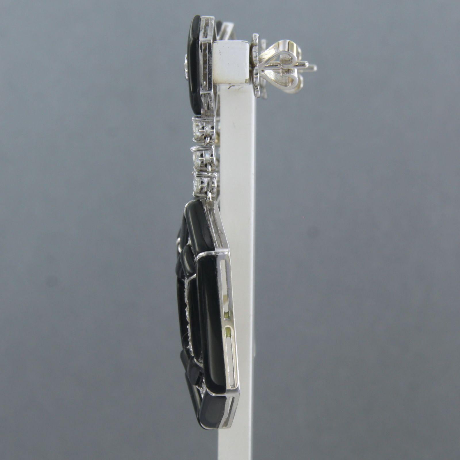 14k white gold earrings set with onyx and brilliant cut diamonds 2.20ct - F/G - VS/SI

Detailed description:

The earring is 4.5 cm long by 2.1 mm wide

weight 13.1 grams

Set with

- 2 x 10 mm octagon shape cut onyx

- 24 x 5.5 mm - 15 mm trapezium