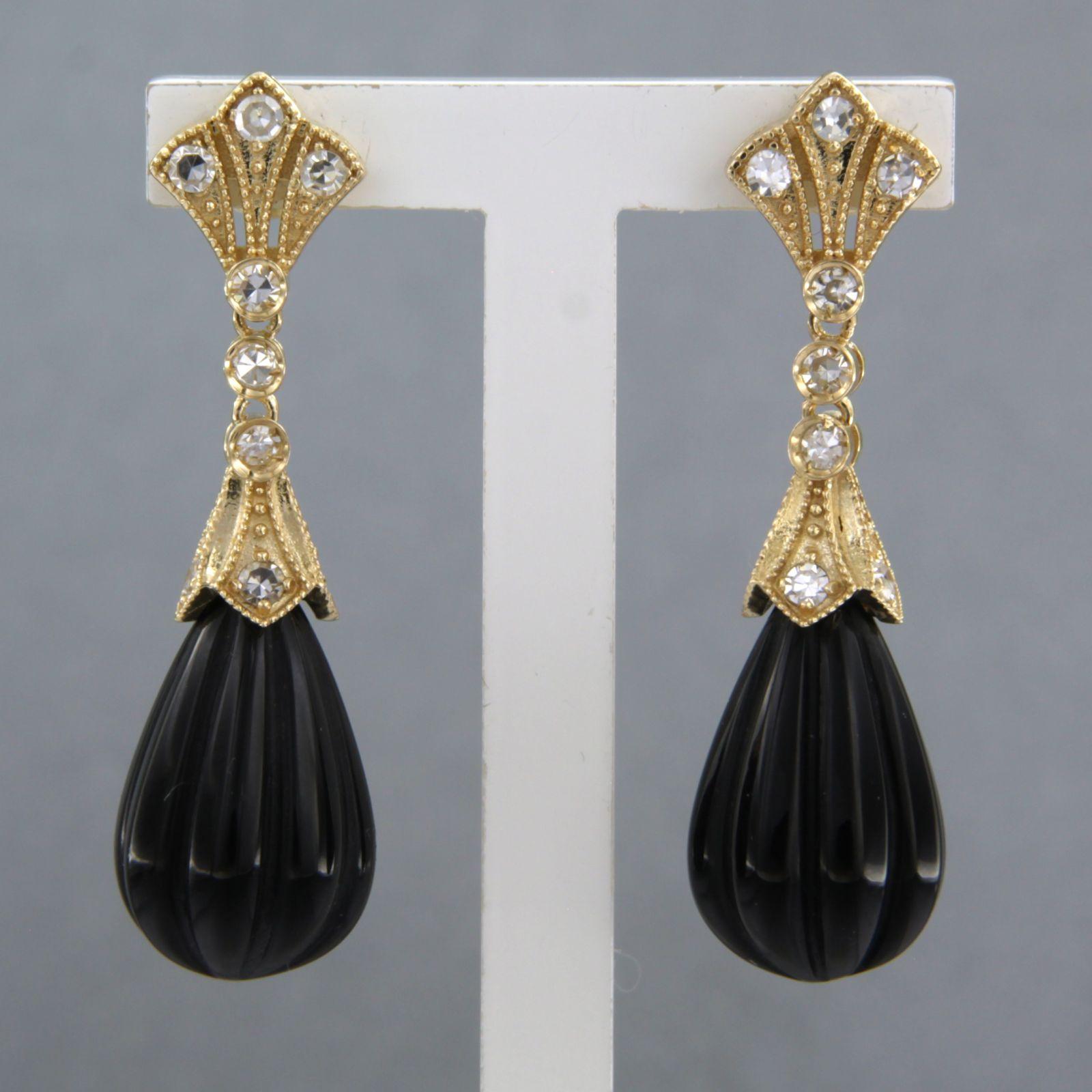 Boucles d'oreilles en or jaune 14k serties d'onyx et de diamants taille unique. 0.42ct - F/G - VS/SI 

Description détaillée :

la taille de la boucle d'oreille est de 3,4 cm de long par 9,5 mm de large

Poids total 6,2 grammes

set avec

- 2 x 1,6