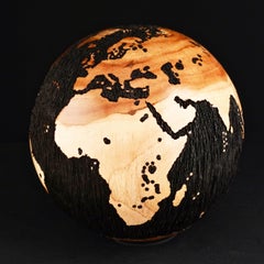 Escultura de un globo terráqueo en negro y con acabado doble de teca