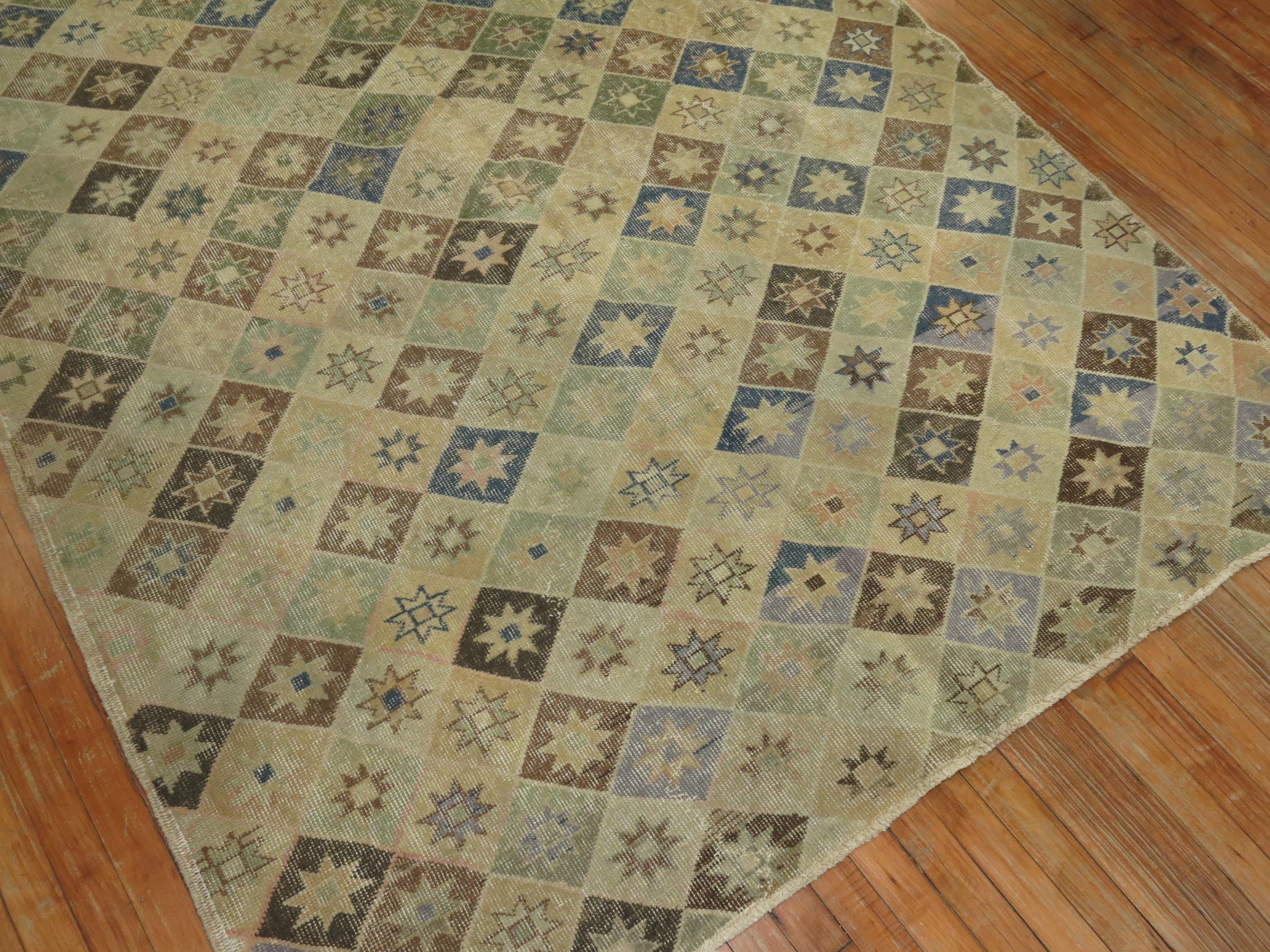 Intermediate size one of a kind midcentury Turkish Deco rug with earth accents in khaki, denim blue, and brown,

circa mid-20th century/ measures: 5'7” x 8'9”.