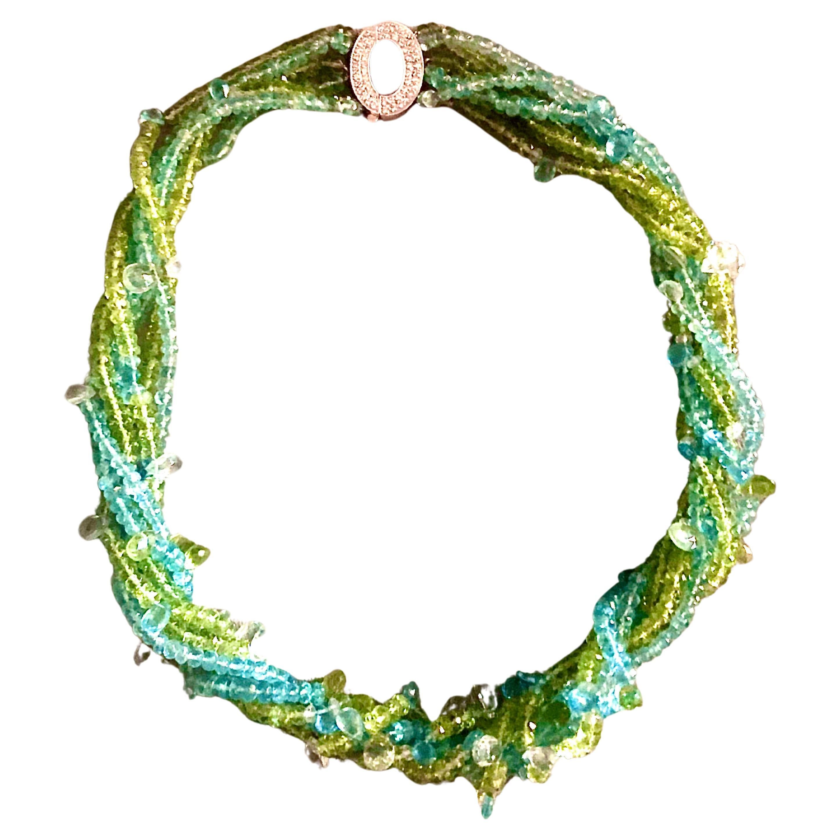 Natural gems from the Earth inspired this necklace. Strands of green peridot and blue aquamarine reflect earth and sky. Woven throughout are sparkling multi size faceted pear-shaped pale aquamarine briolettes glistening like new fallen raindrops .