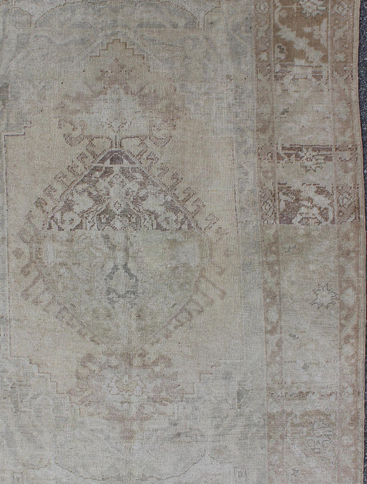 Hand-Knotted Earth Tones Antique Turkish Oushak Rug with Faded Colors in Medallion Design For Sale
