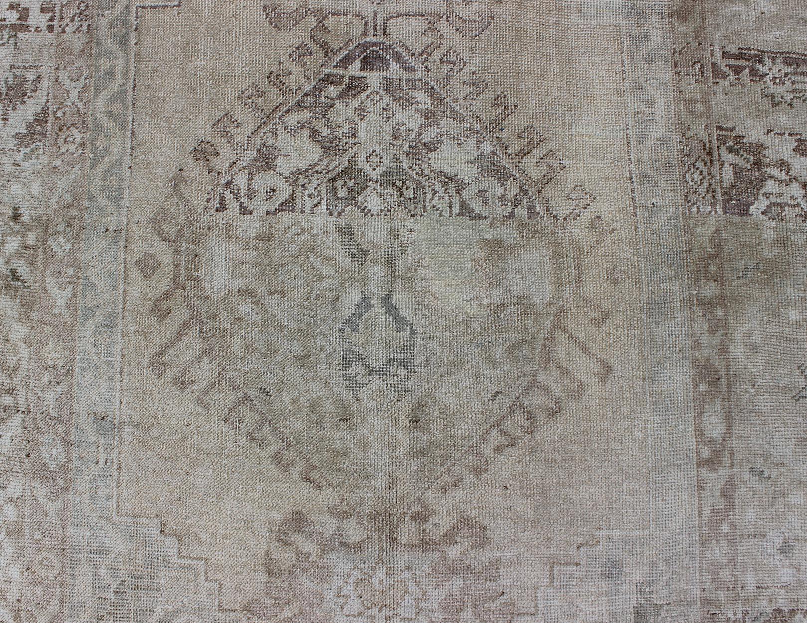 Mid-20th Century Earth Tones Antique Turkish Oushak Rug with Faded Colors in Medallion Design For Sale
