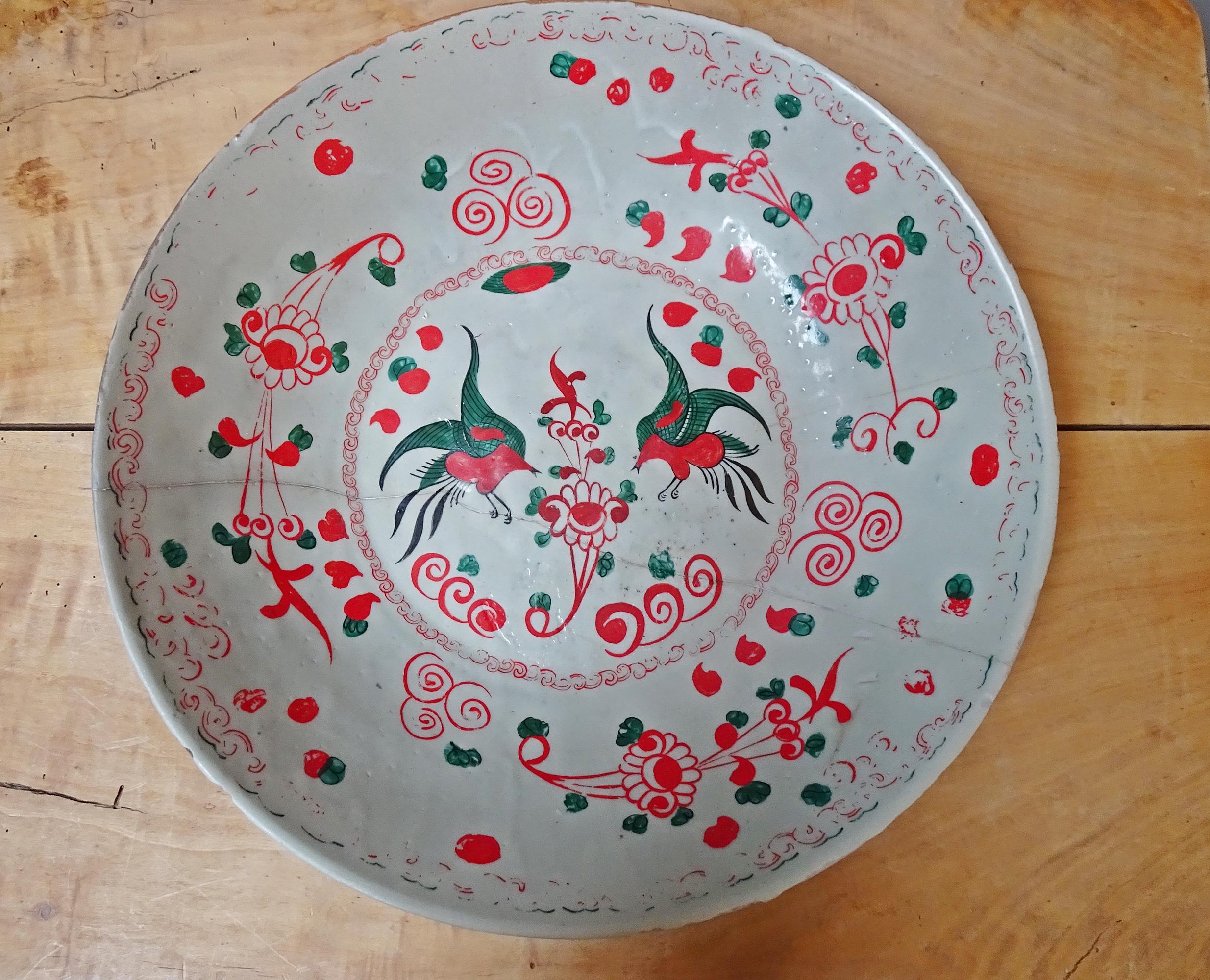 Cuenco antiguo de cerámica del siglo XVIII. Cerámica vidriada al estaño con pintura en barbotina de color rojo, verde y negro. Una decoración especial, adornada con detalles florales y dos pájaros míticos. La decoración recuerda a la cerámica