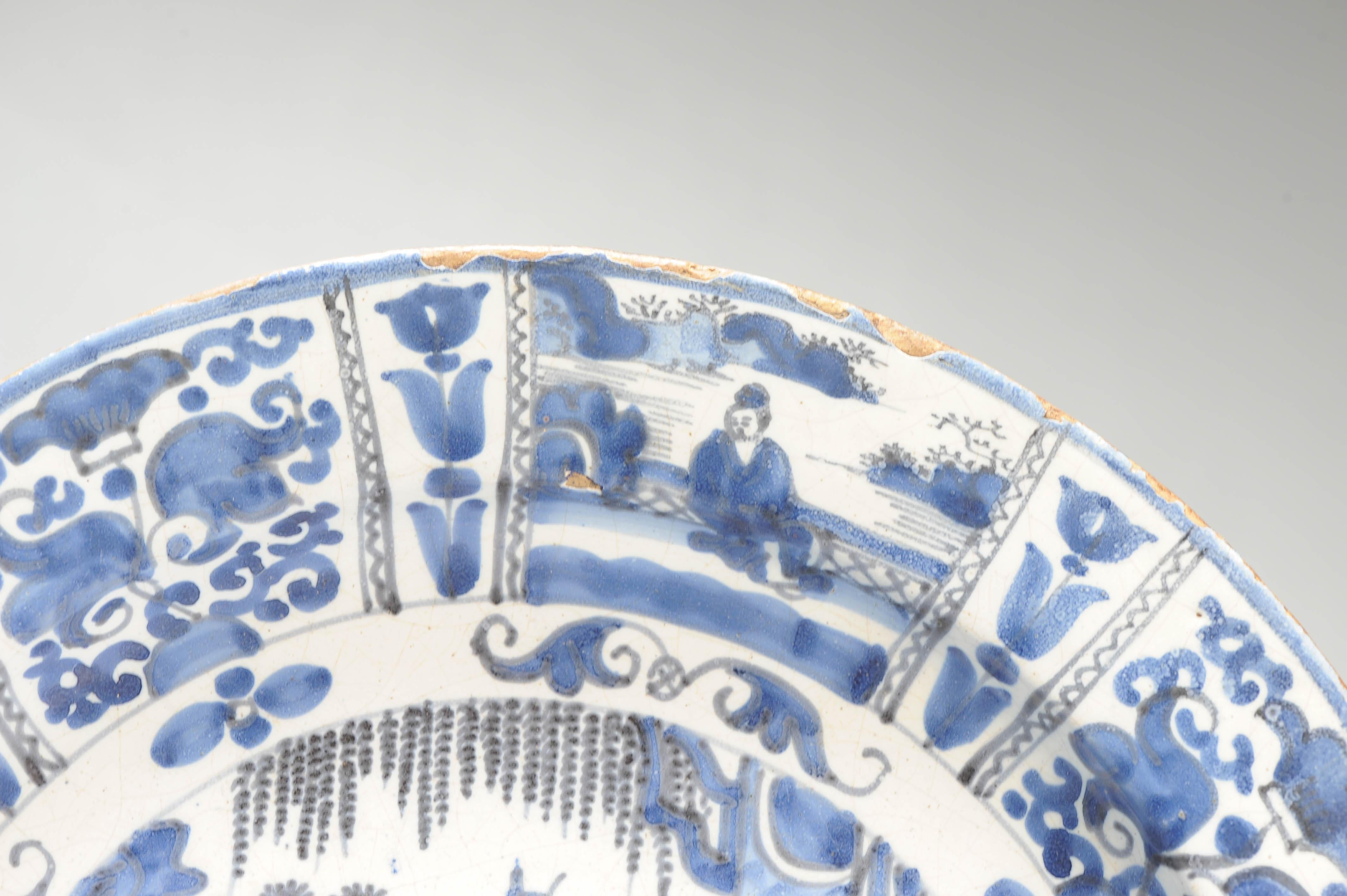 Plato de barro con borde plano. Decorado en diferentes tonos de azul sobre un whi Europeo en venta