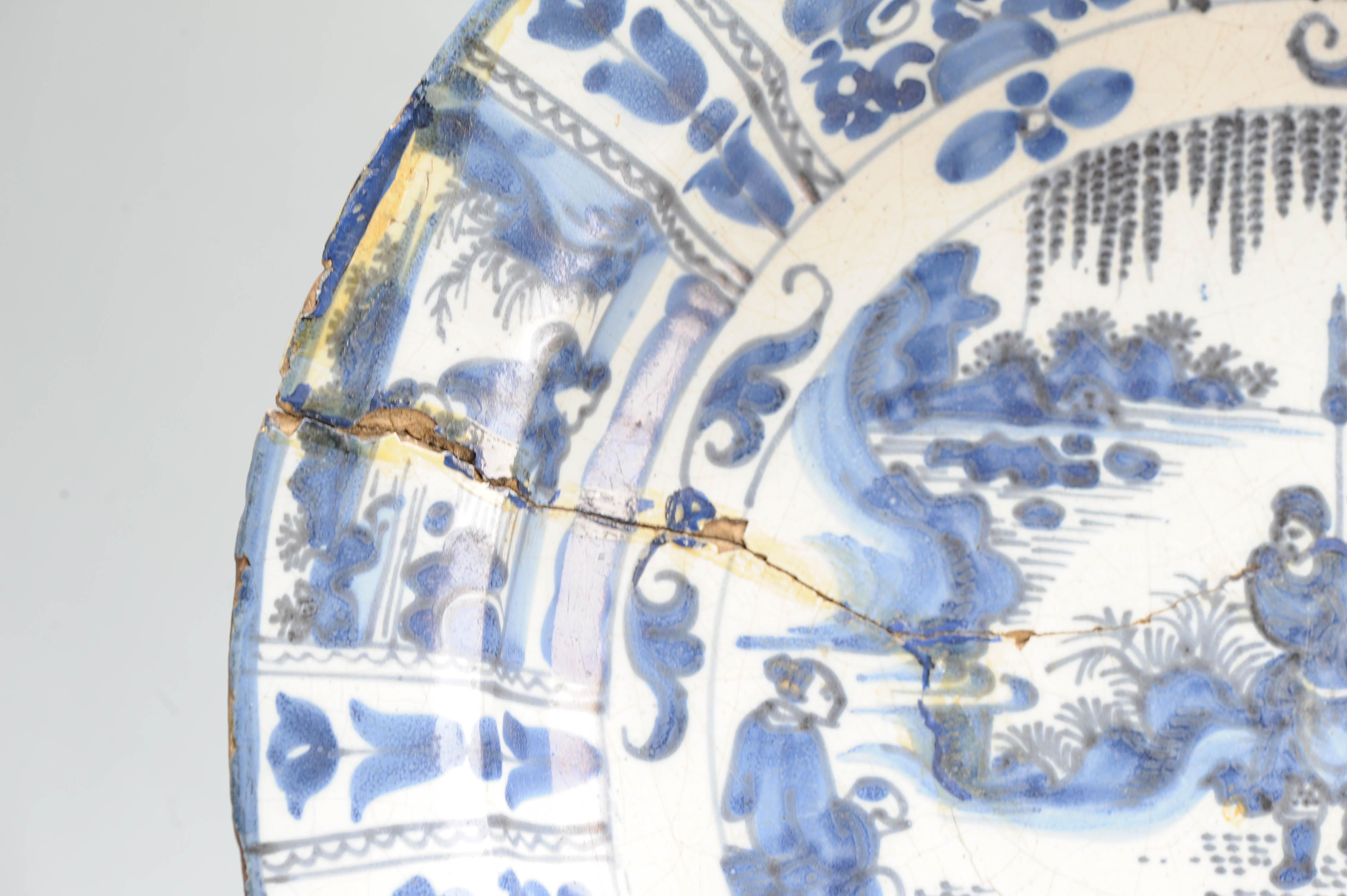 Plato de barro con borde plano. Decorado en diferentes tonos de azul sobre un whi Porcelana en venta