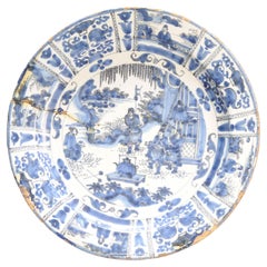 Plato de barro con borde plano. Decorado en diferentes tonos de azul sobre un whi