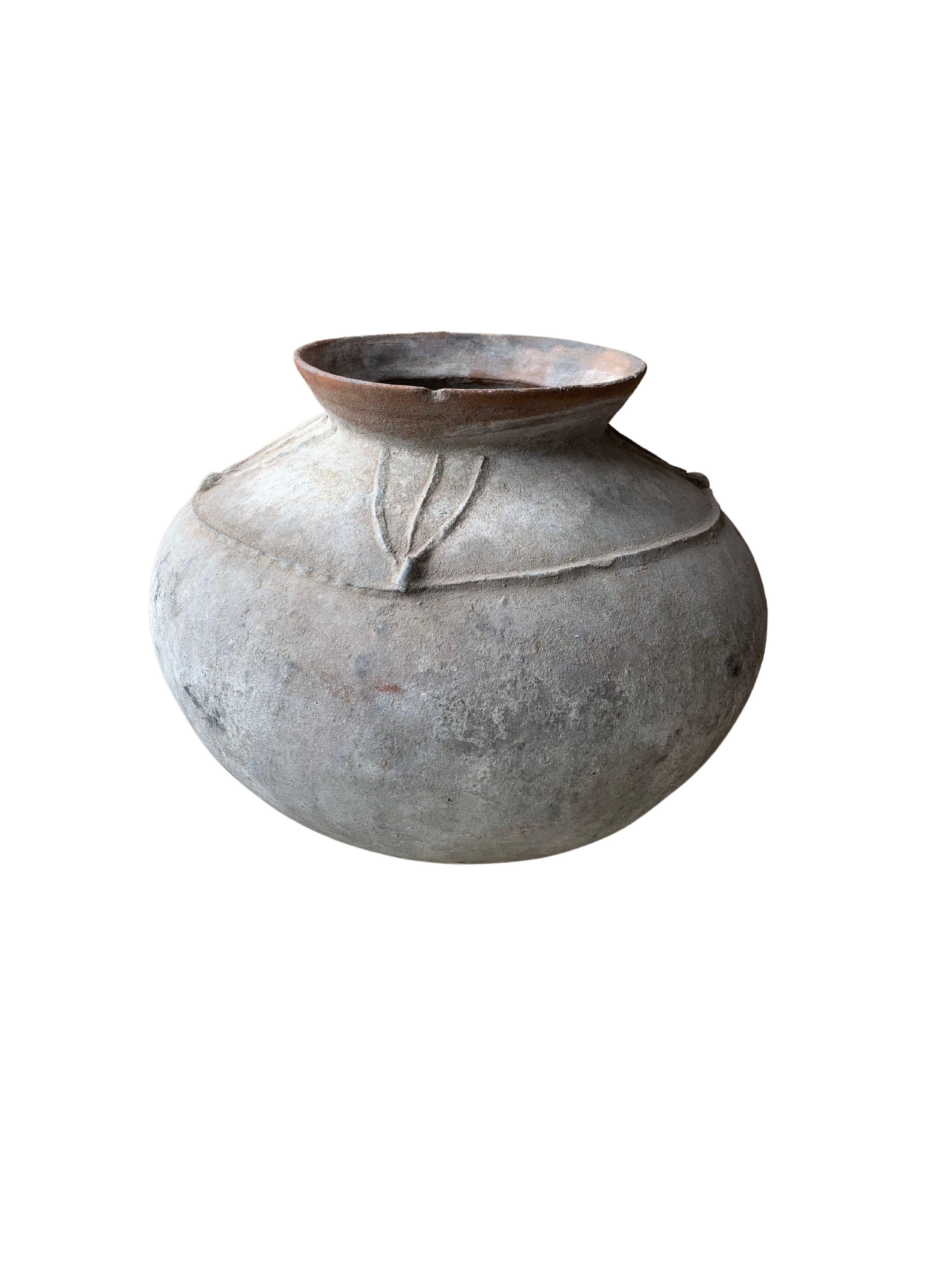 A visibly old Earthenware Pot from the Island of Sumba in Indonesia. A unique piece to add to a pottery collection or home decor. It features tribal motifs on its exterior. The pot has a wonderful age related patina and texture. Pots such as these