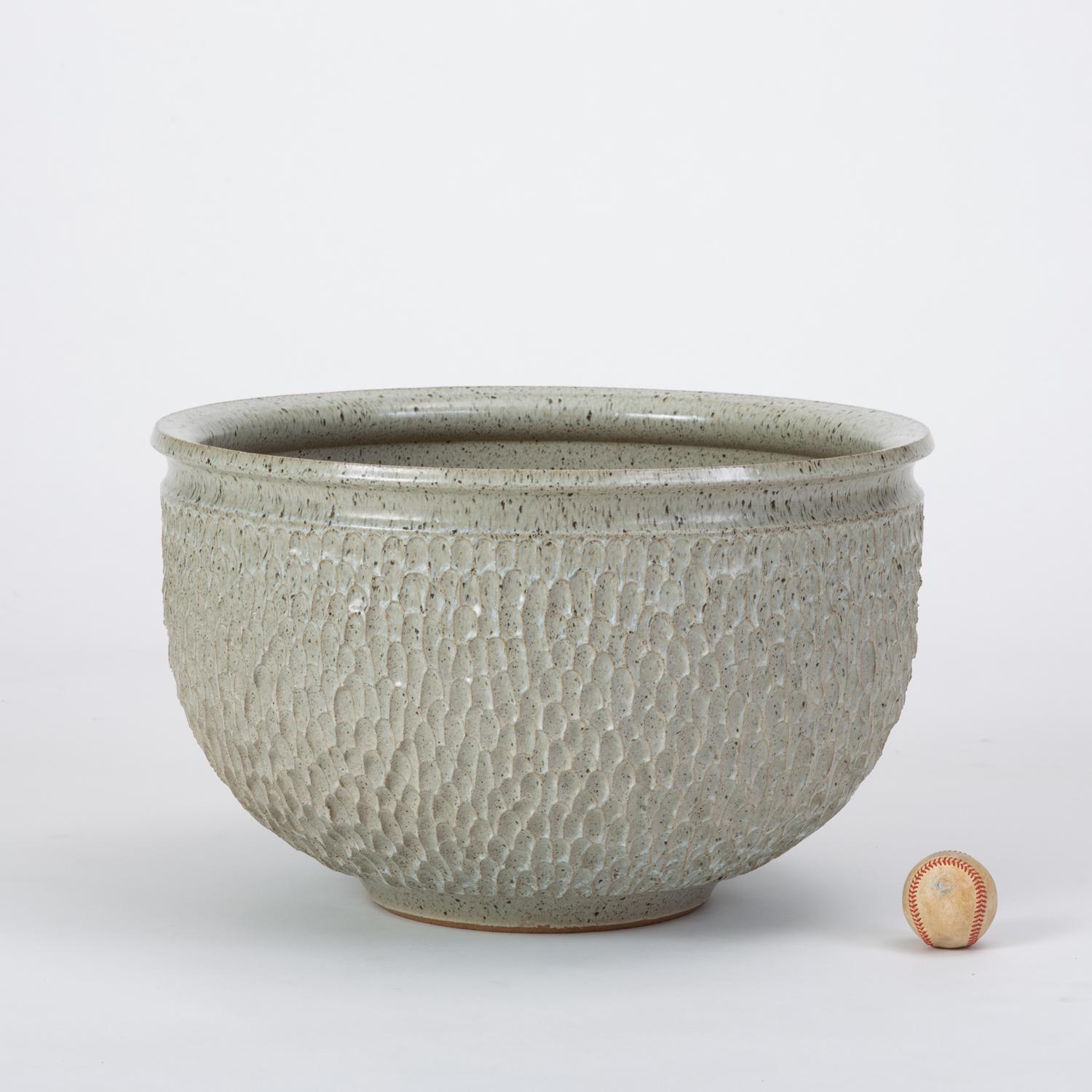 A wide stoneware planter from Robert Maxwell and David Cressey’s 1970s collaboration, Earthgender. One of the less common designs from this partnership, the ‘Pebble’ pattern has a textured surface of repeating impressed concavities. This example has