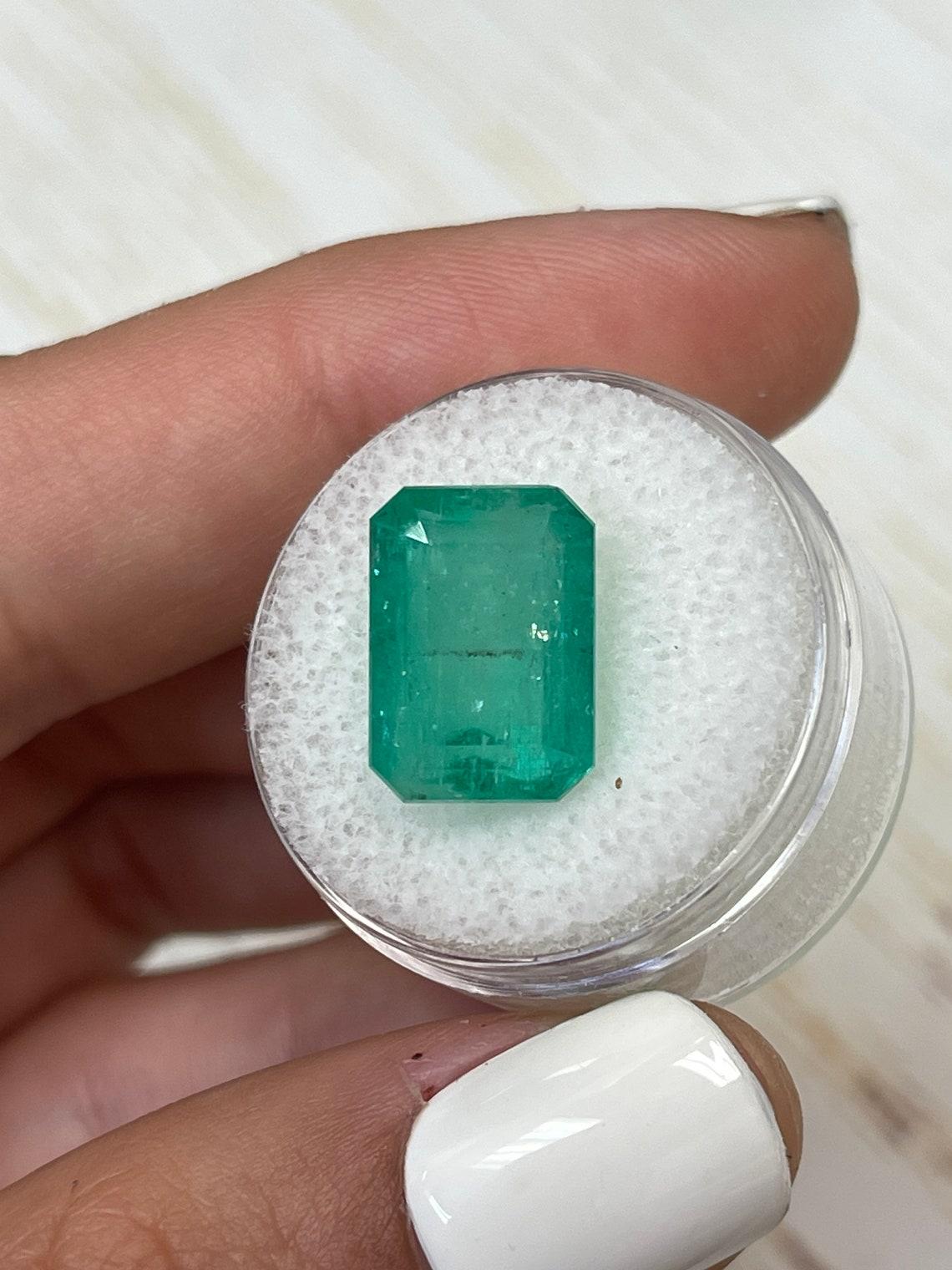 Stone: Emerald
Weight: 10.03-carats
Shape: Emerald Cut
Clarity: Transparent
Luster: Good
Color: Green
Measurements: 14.10mm x 10.01mm x 8.35mm
Geographic Origin: Colombia
Treatment: Natural, Oiling

Comments: Due to their growth conditions in nature