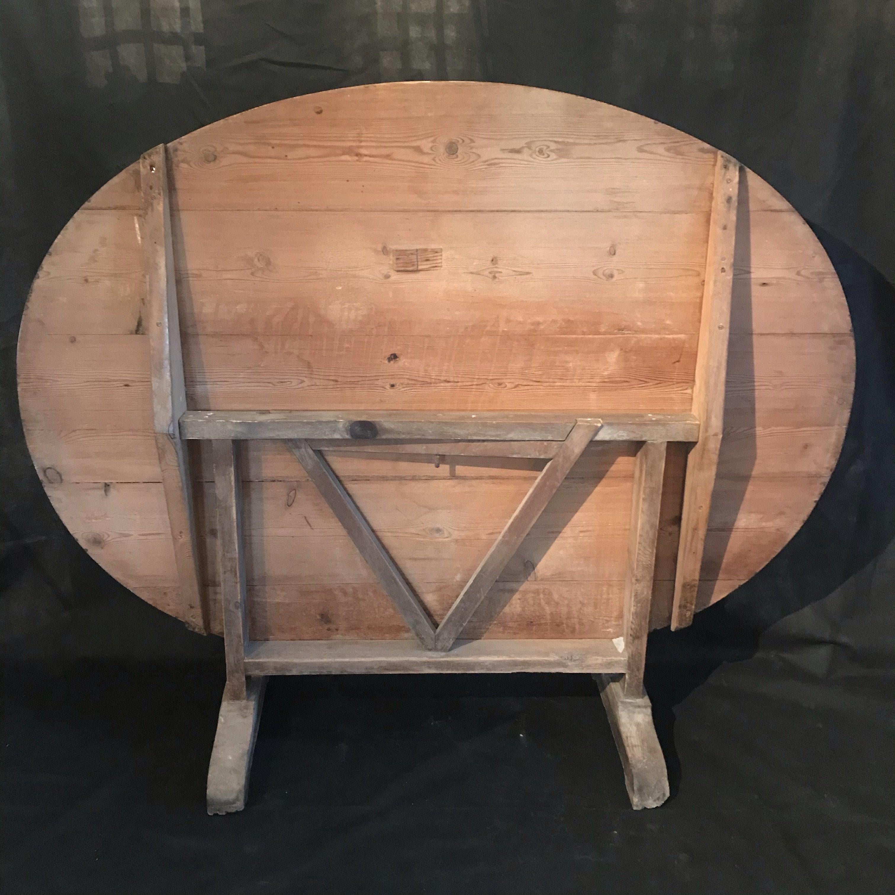 Large French oval wine tasting table, also known as a vendage or vigeron
table, which was once used in the vineyards of France for tasting wine or
enjoying a meal. This table would be suitable for use in a breakfast area or
wine cellar. Featuring