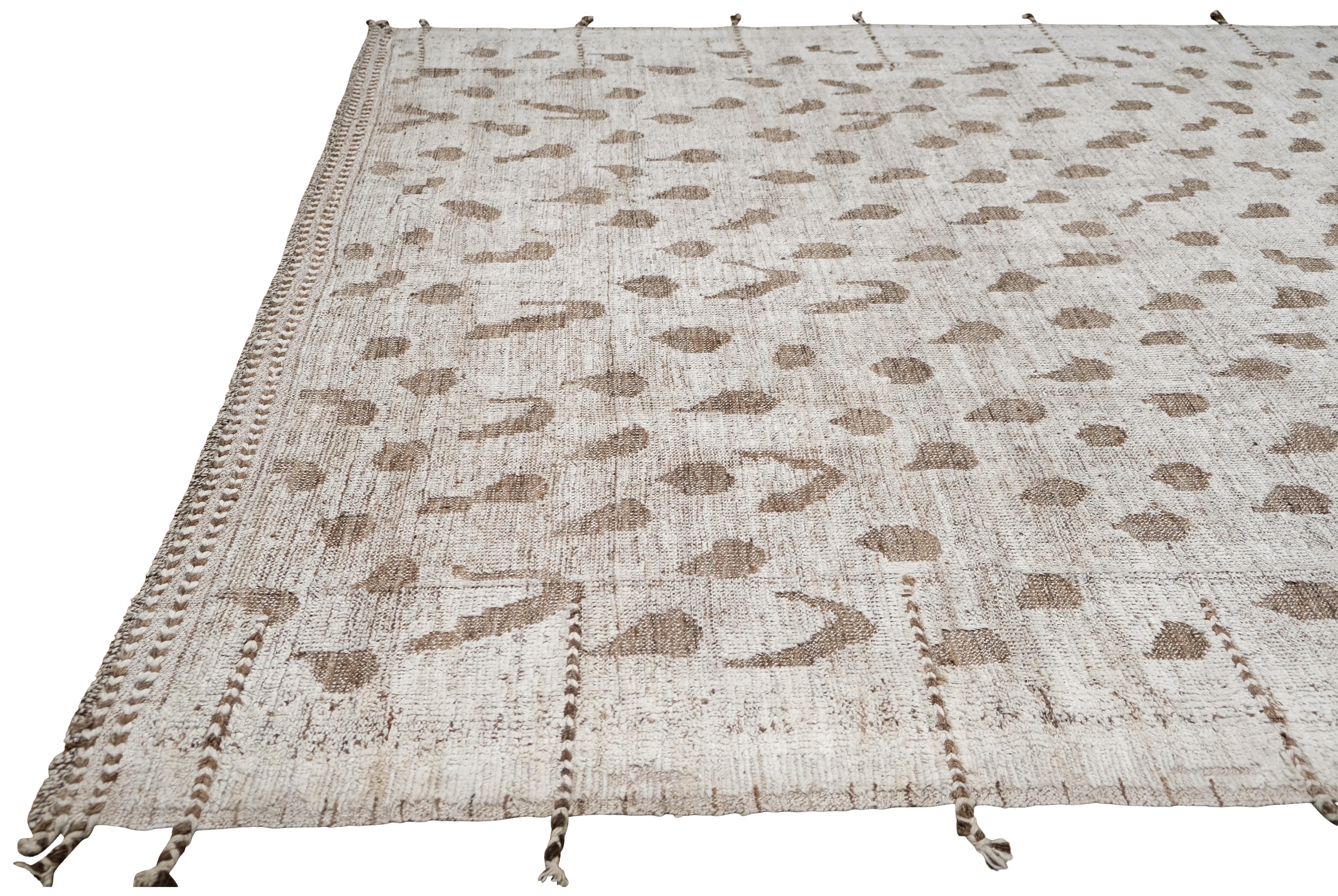 This exquisite hand-knotted wool rug brings a sense of understated elegance and organic artistry to any space. Measuring approximately 8'7