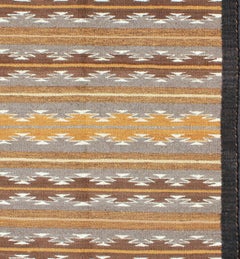 Alfombra Navajo Kilim de tonos terrosos USA con borde negro de diseño tribal