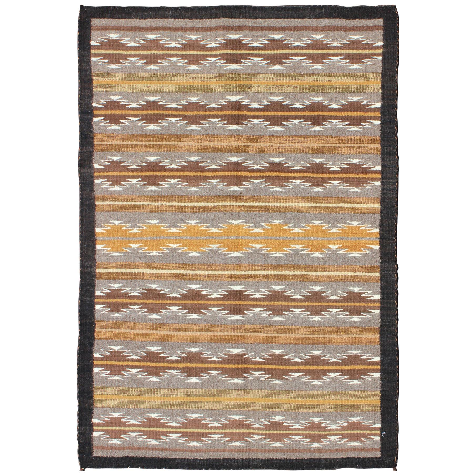 Tapis Kilim Navajo USA aux tons terreux avec bordure noire et motif tribal