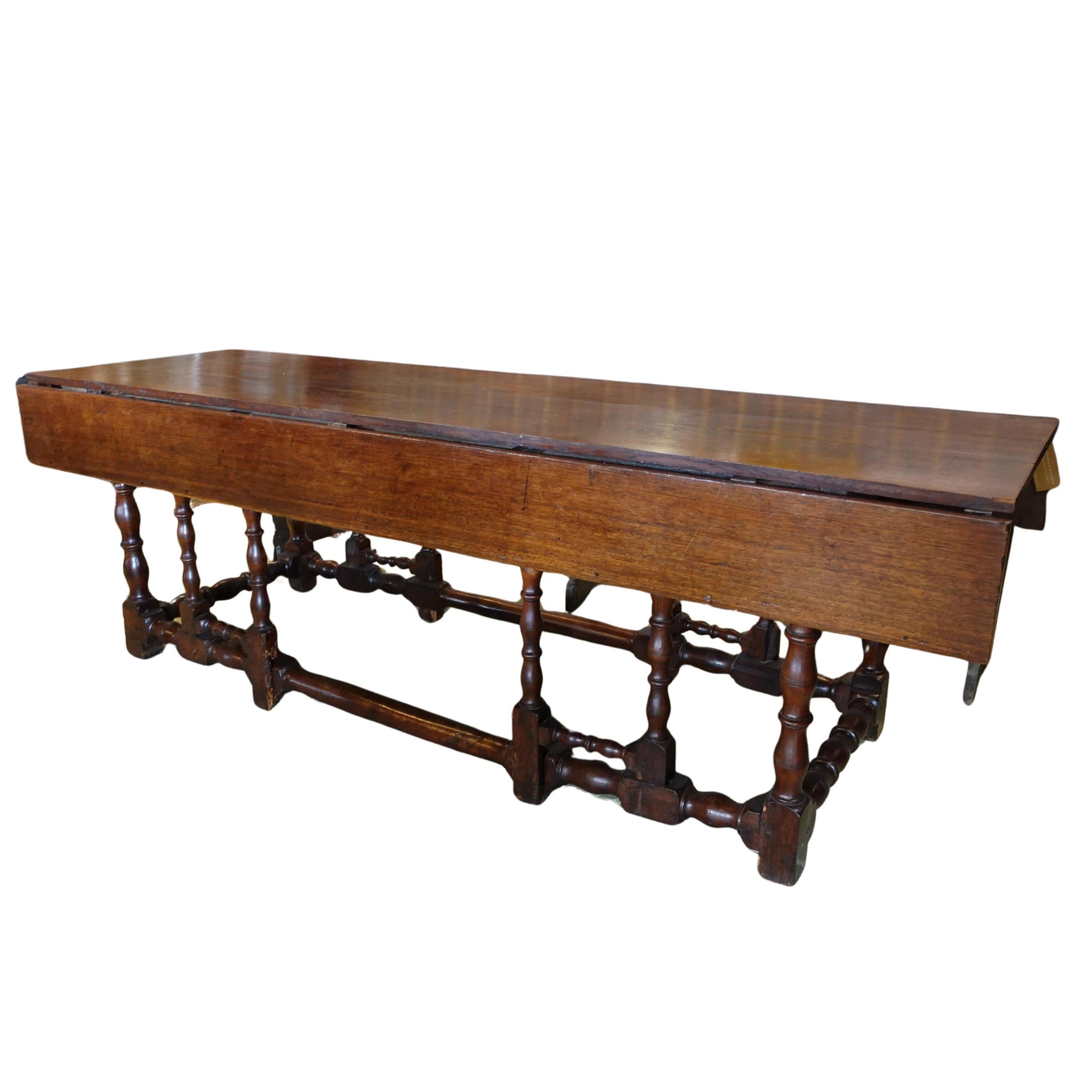Eary 1800s English Oak Wood Drop Leaf Table

Approximate size: 30”H x 96”W x 27”D; or 42”D w/ leaves up

Crafted from exceptionally dense English Oak, this remarkably long tavern style gateleg table is surprisingly heavy, a testament to the robust