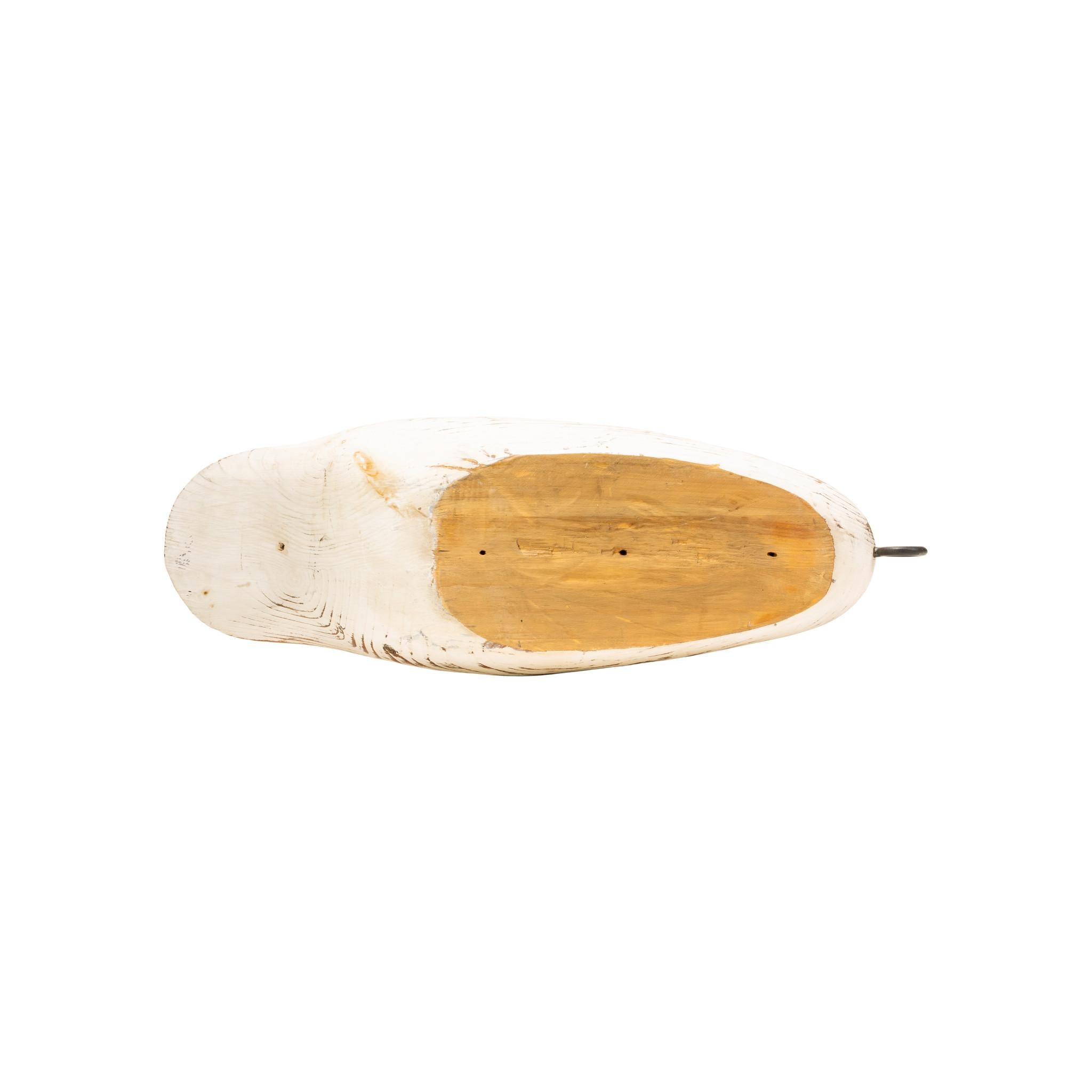 Señuelo decorativo de cisne con plumas talladas y ojos de cristal. Pintura lijada de forma que se vea ligeramente la madera que hay debajo. El cuello es largo y delicado, con detalles sin pintar alrededor de los ojos y en el pico. Una pieza bien