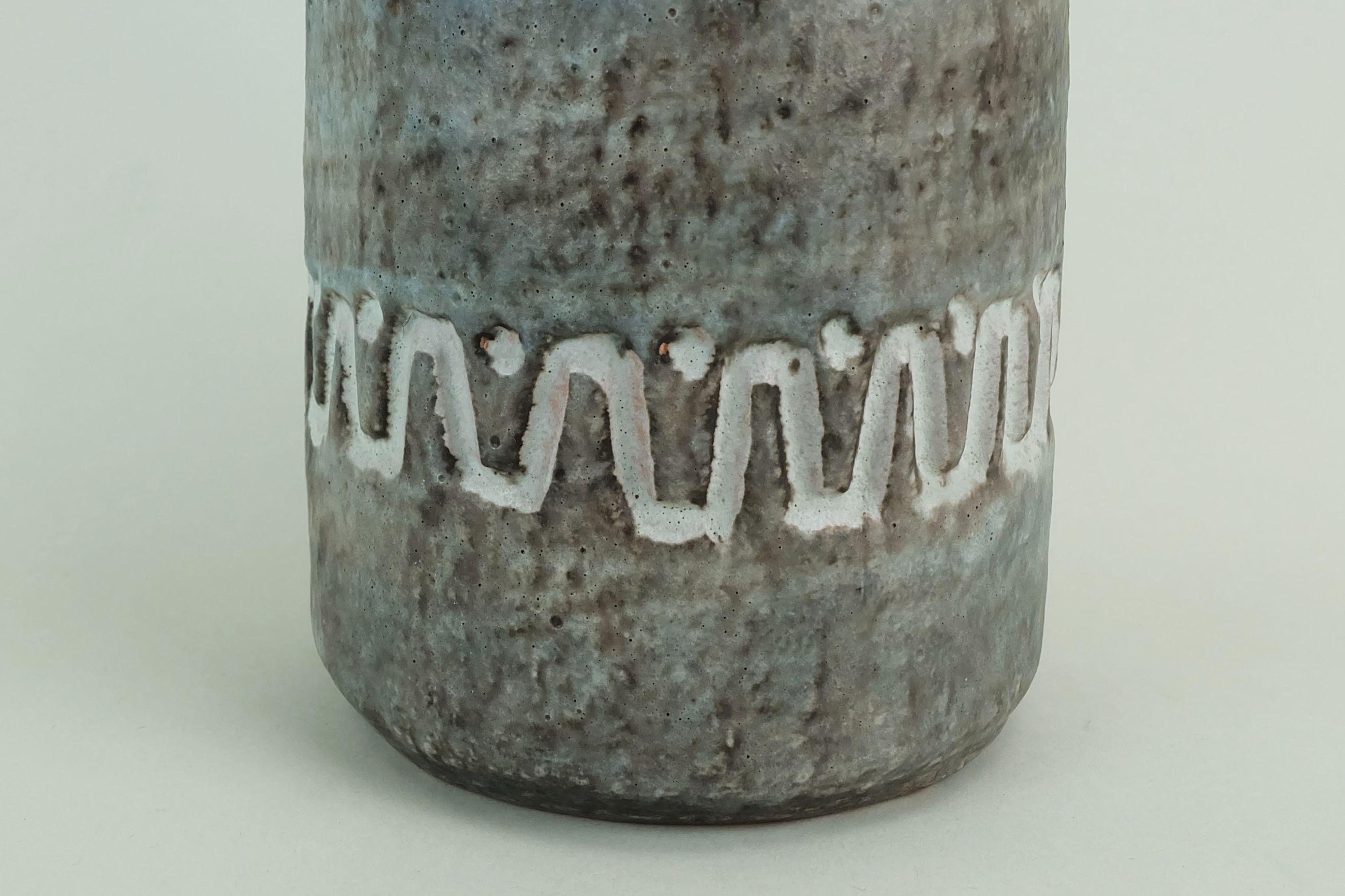 Vaso in ceramica degli anni '60 con smalto blu, marrone e grigio e decoro sgraffito bianco sporco. Marcato sul fondo V.I.I. 32. Progettato da August Heissner, Gräfenroda, Germania orientale.

Dimensioni in cm:
Altezza 31 cm, diametro massimo 12