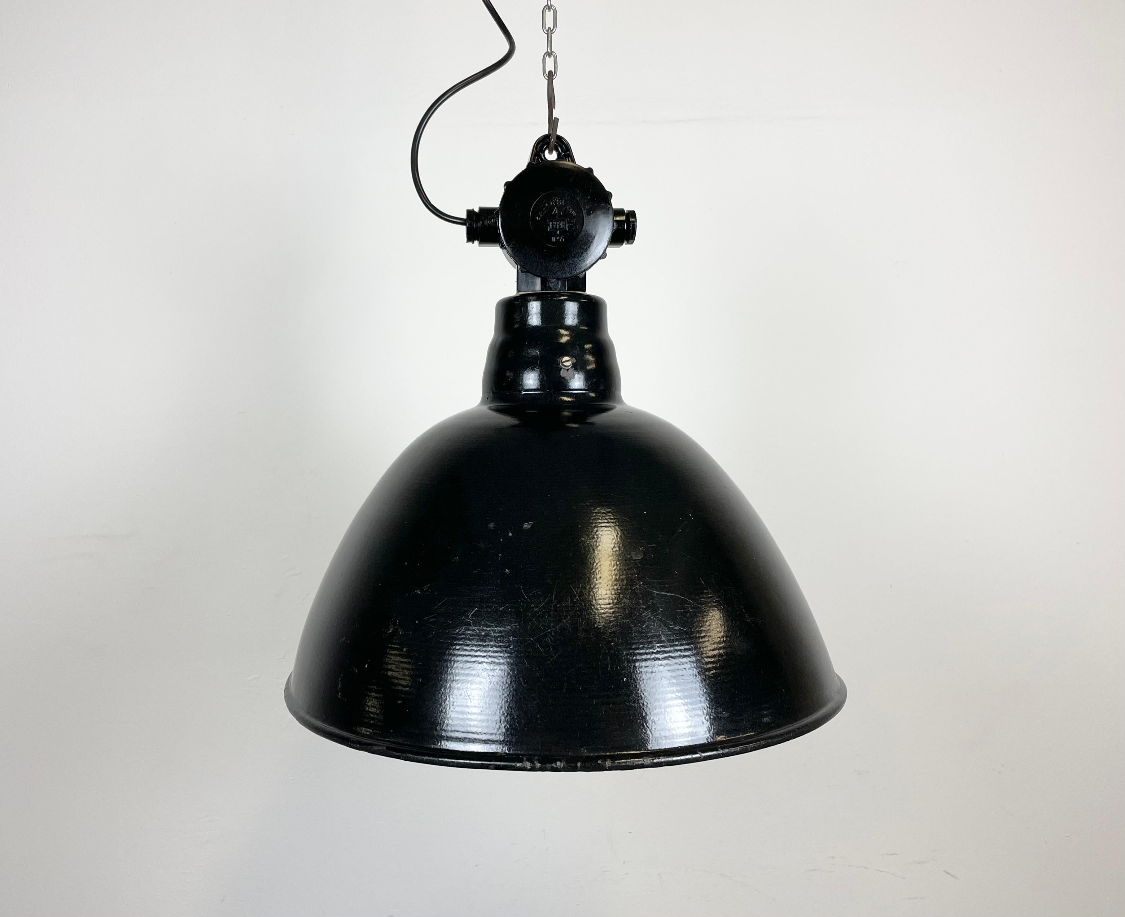 Industrial enamel factory light made by Lbd Veb Leuchtenbau Dresden in East Germany during the 1950s.It features black enamel shade with white enamel interior and bakelite top.The porcelain socket requires E 27 light bulbs. New wire. The weight of
