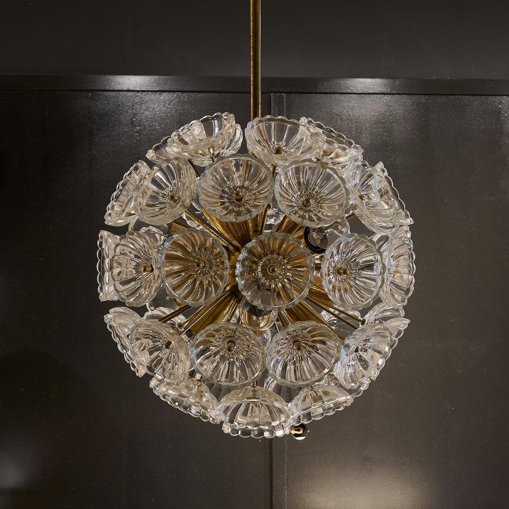 An exceptional vintage brass chandelier with 52 thick glass blossoms. This style light fixture previously hung in the Palace of the Republic in East Germany and is an extremely rare piece. The design is based on a Dandelion. 

Requires 12, E14
