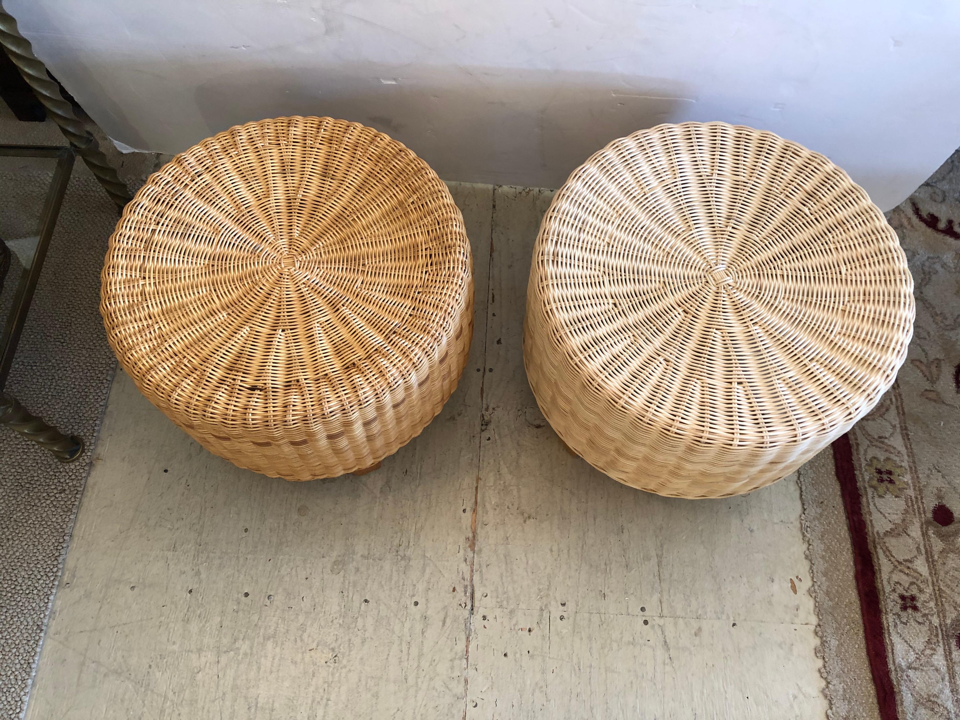 Great looking pair of woven rattan and wicker round ottomans having 4 tapered light wood legs. Perfect for a stylish beach house. One ottoman is slightly darker than the other.